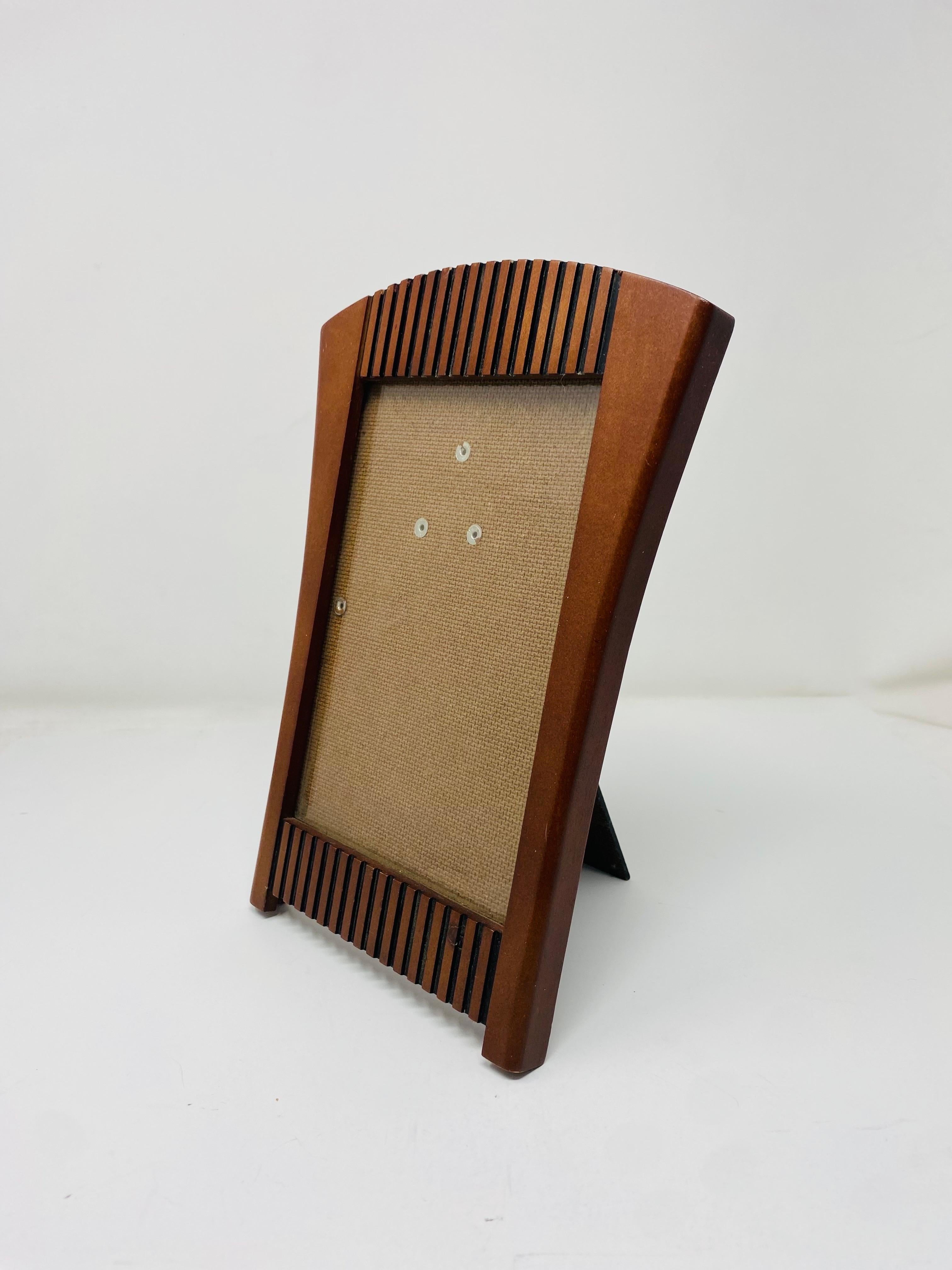 Stylish and architectural wooden plated photo frame.  Stylish and unique, this piece follows design inspiration from Michael Graves and the Arts and Crafts movement with its design, style and architectural details.  This piece is luxury and chic.