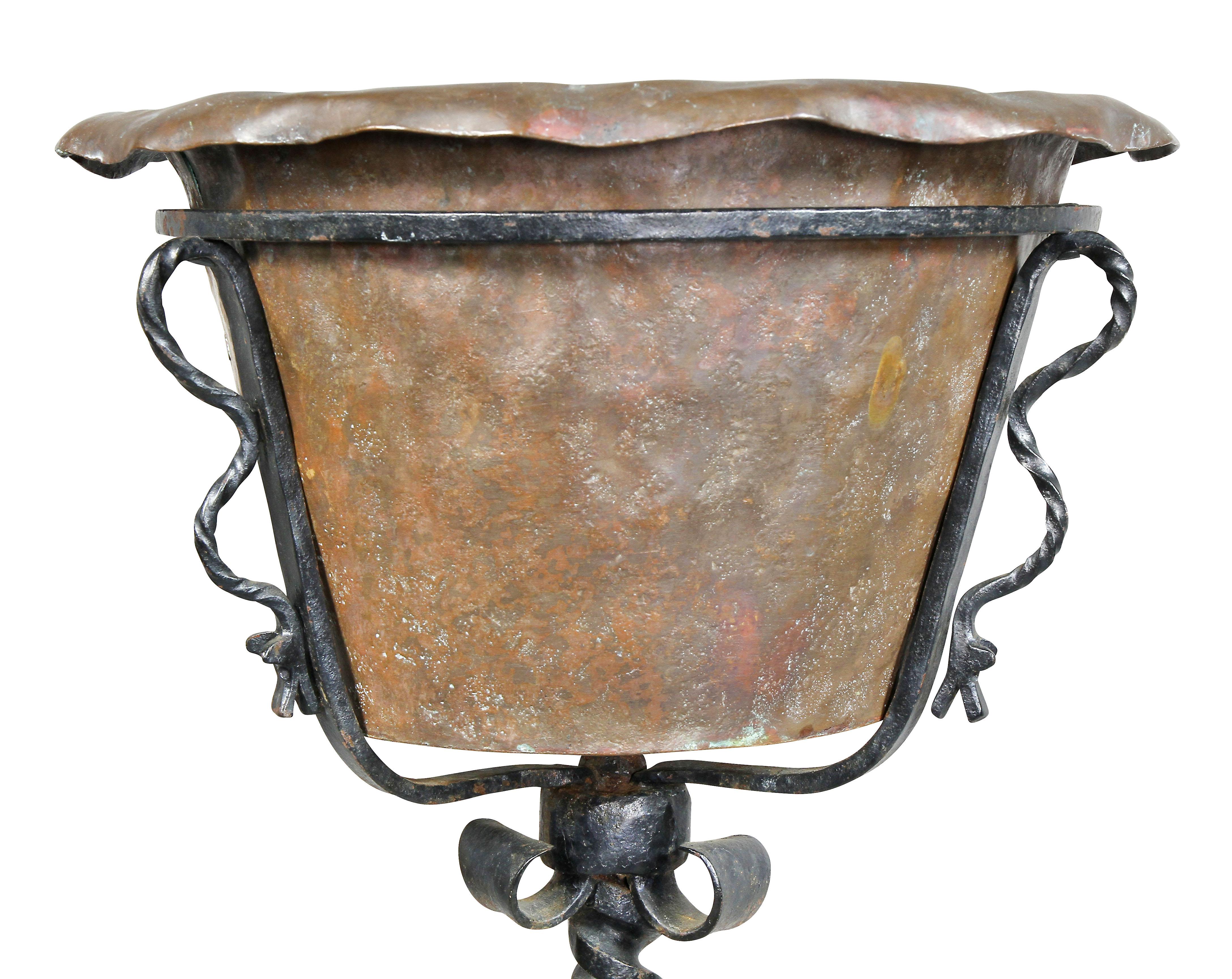 Removable copper handwrought bowl fitted into a wrought iron holder and raise on a twisted support and tripod legs. Attributed to Samuel Yellin.