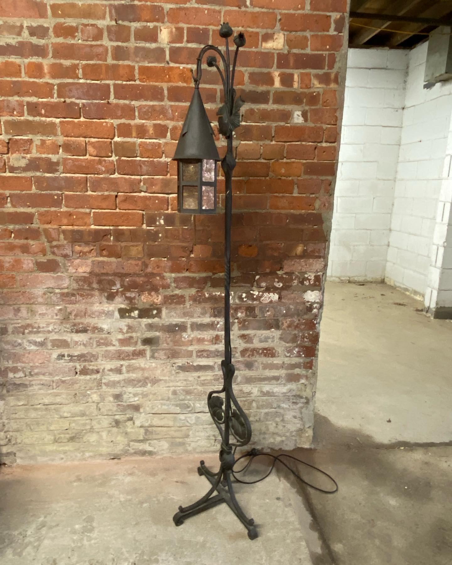 Wrought iron floor lamp with hexagonal mica panel shade. Scroll and foliate three foot base topped with a 