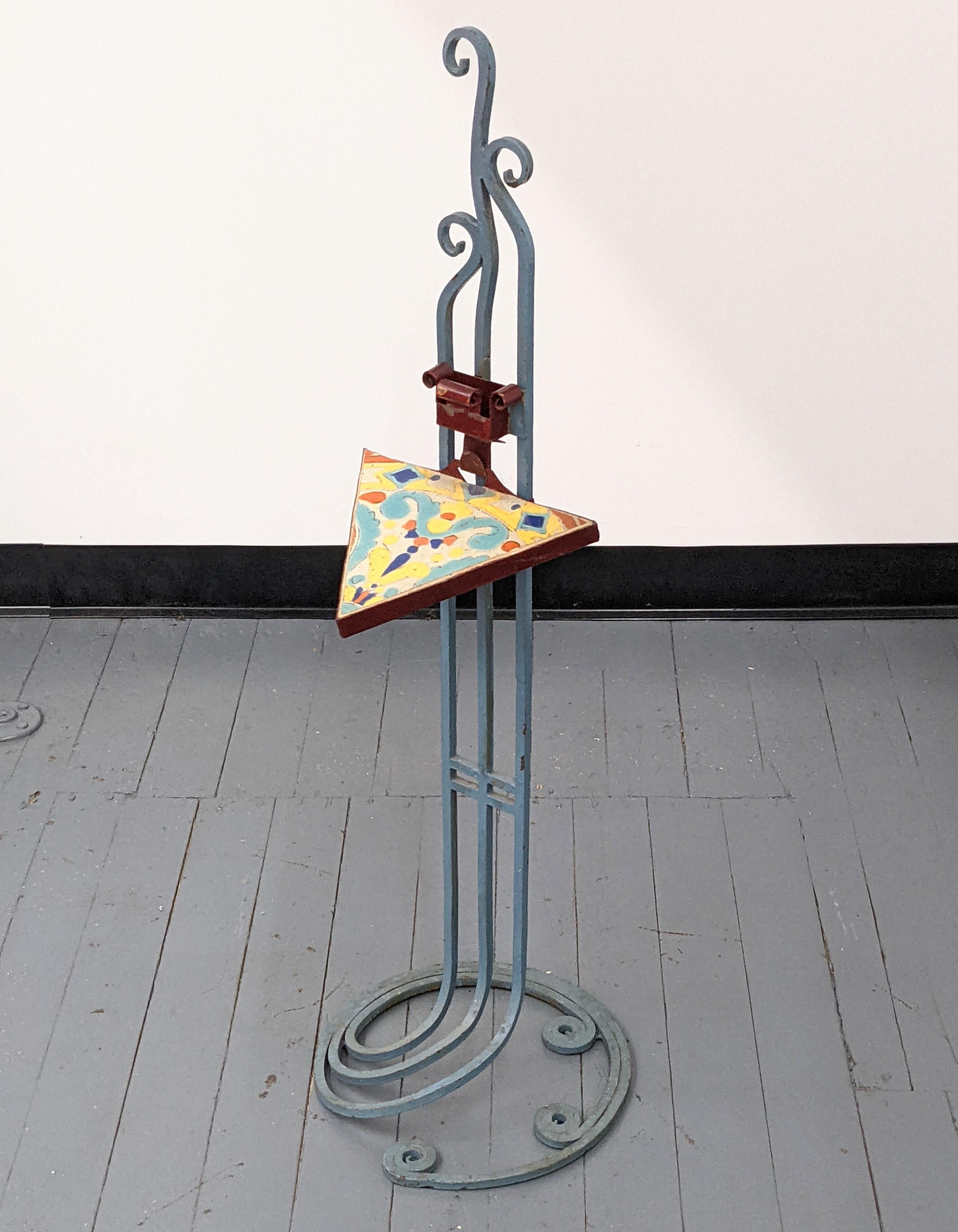 Arts and Crafts Wrought Iron Stand with Glazed Tile designed as a smoking/drink stand. Colorful glazed Mexican/Californian tile triangle. The stand is enameled in a bluish grey with an opening for a match box enameled in deep burgundy. The tile is