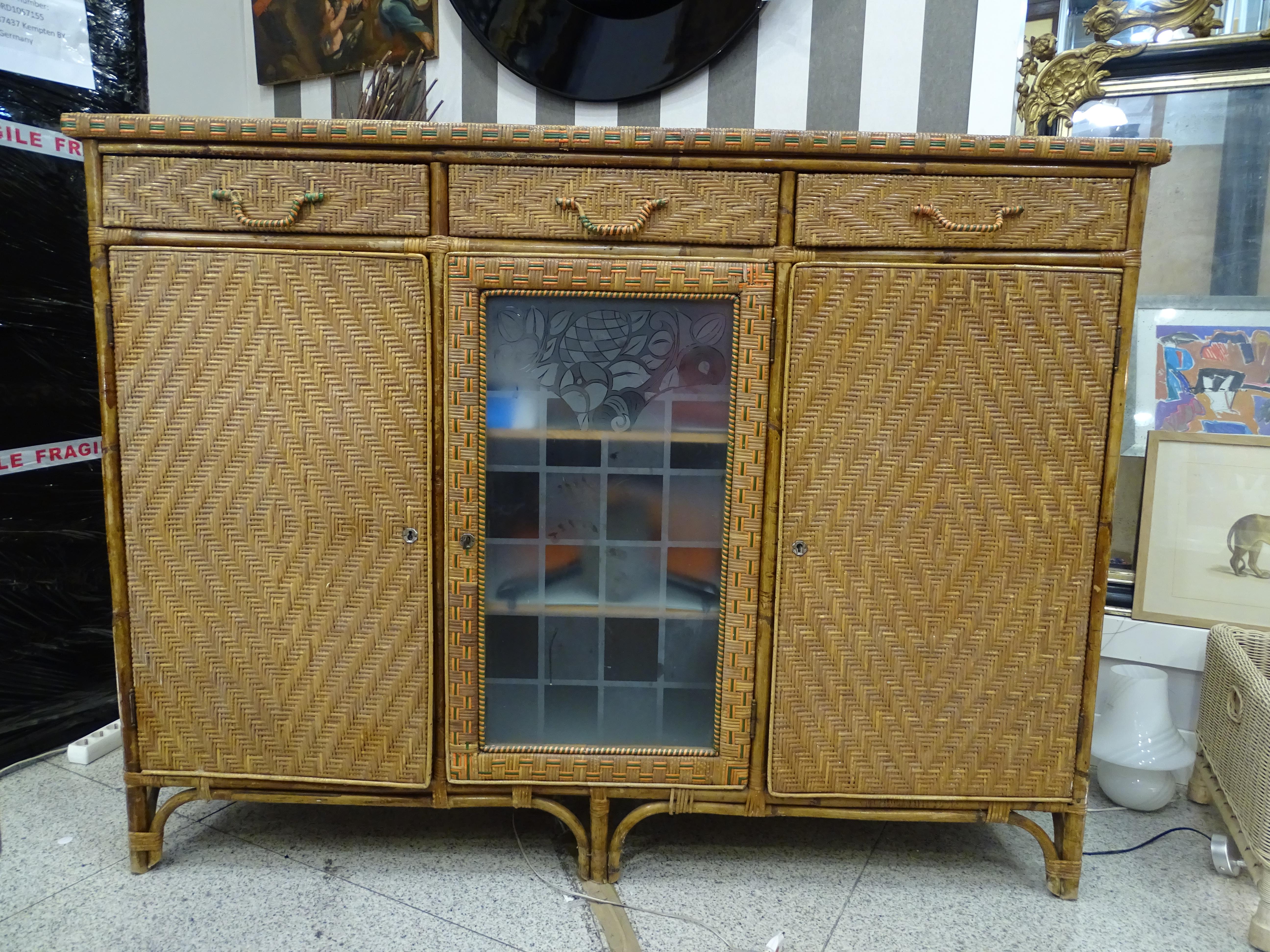 Amazing and very funny buffet in carved wood and rattan , Arts and Crafts . It has 3 drawers and 3 doors, the door midle has a acid etched glass with floral and geometric motifs.
The rattan has differnt colors, natural with orange and green, giving