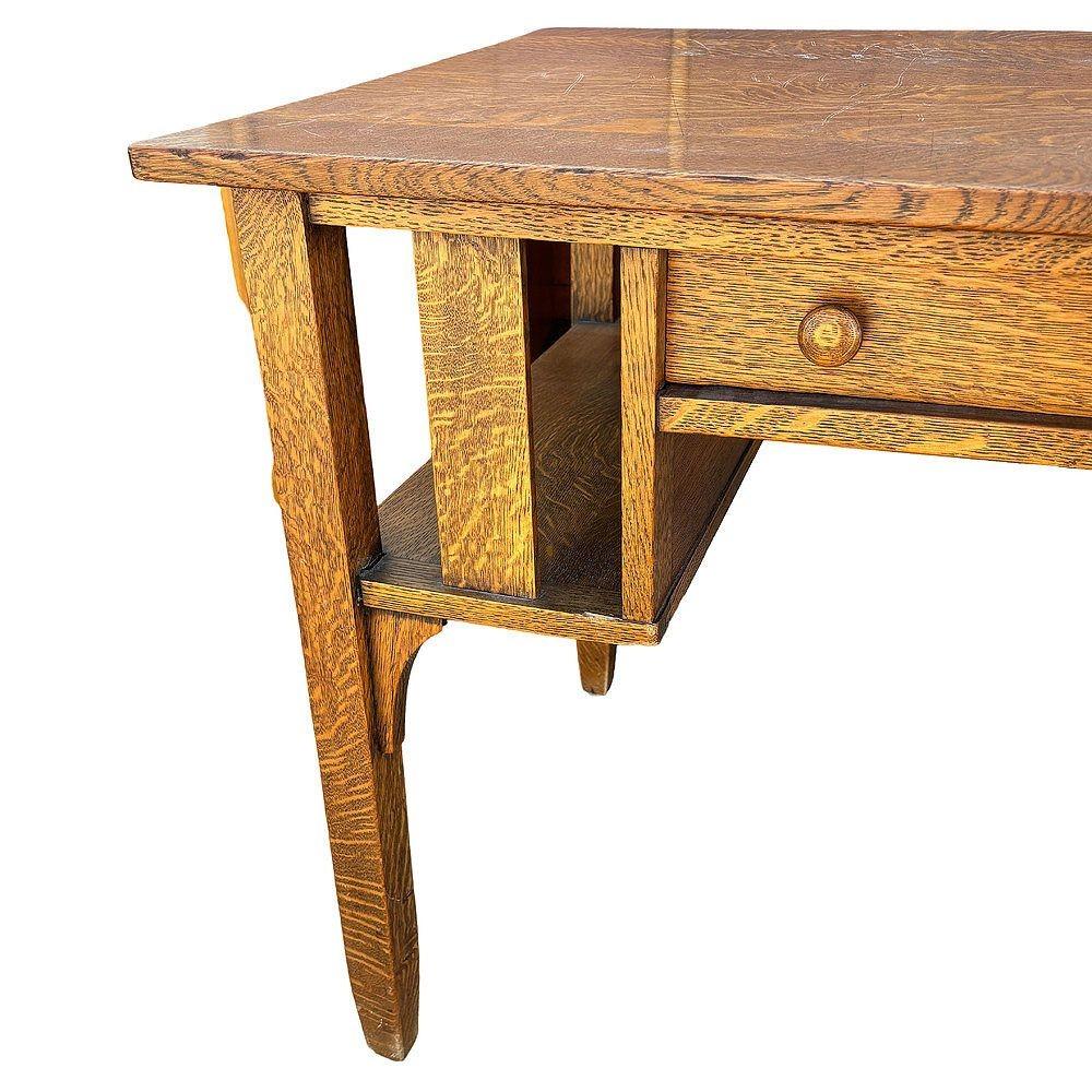 Escritorio Arts & Craft de roble aserrado con 3 cajones y estantería lateral. El escritorio presenta un distintivo veteado de madera asistido con muebles de la época de la Misión, cerraduras de latón y tiradores de madera originales. Su elegante