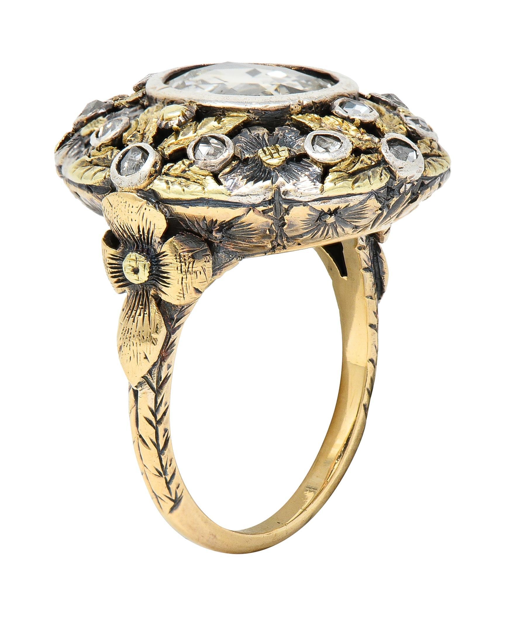 Centering an oval-shaped rose cut diamond weighing approximately 1.02 carats - bezel set
With a pierced domed surround of silver and gold floral and foliate motifs with engraved detail
Featuring an additional rose cut diamonds bezel set throughout