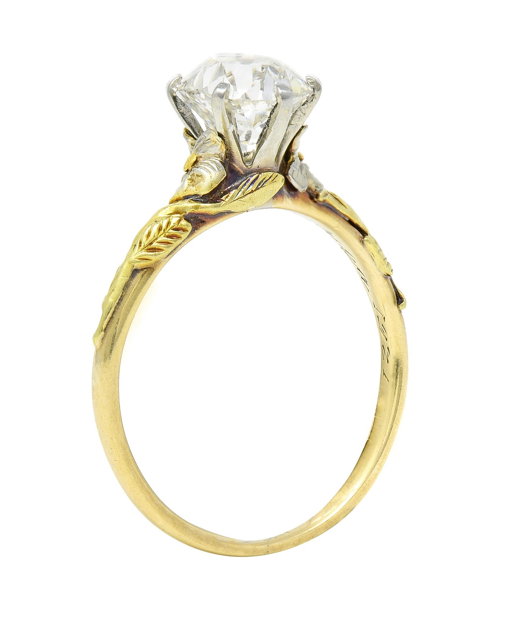Centering an old mine cut diamond weighing approximately 1.28 carats - I color with SI1 clarity
Set in a six-prong white gold mounting with a highly rendered floral surround
Featuring green gold stems with white gold flowers and yellow gold