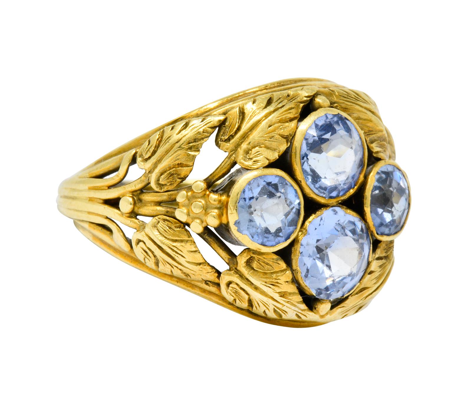 Ring designed as highly rendered leaves with floral shoulder accents

Centering four bezel set sapphire weighing approximately 2.20 carat total; very well-matched medium-light violetish-blue color

Tested as 14 karat gold

Circa: 1905

Size: 4 1/2 &