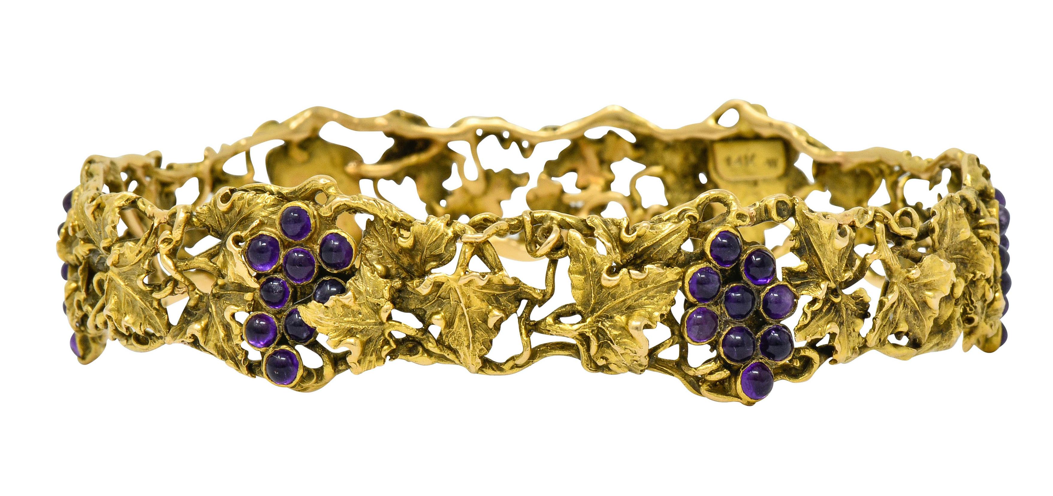 Bangle style bracelet comprised of meandering gold vines and highly rendered grape leaves

With six clustered bunches of grapes comprised of 2.5 mm round amethyst cabochons

Incredibly well-matched and a bright saturated purple in color

With