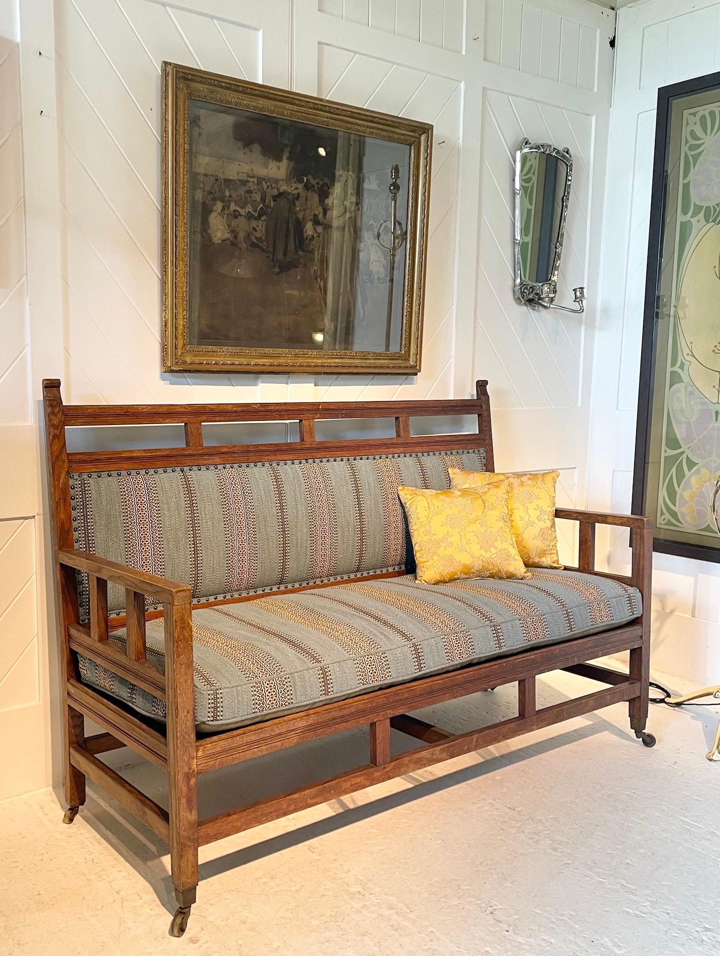 Arts & Crafts oak framed settee 
Raised on brass square castors
Re-upholstered

Anglo-Japanese design

In the manner of E.W. Godwin

Circa 1890
