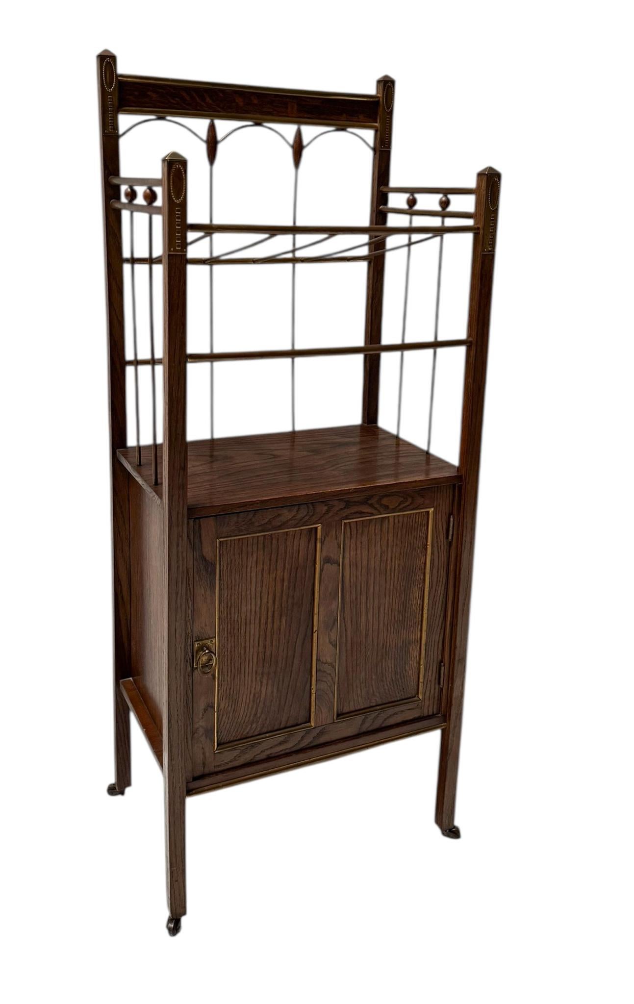 Magnificent and rare Arts & Crafts Art Nouveau magazine stand.
Design by Meubelmagazijn Rembrandt Amsterdam.
Striking Dutch design from the 1900s.
Original oak and brass frame with integrated door.
Marked with original manufacturers metal tag at the