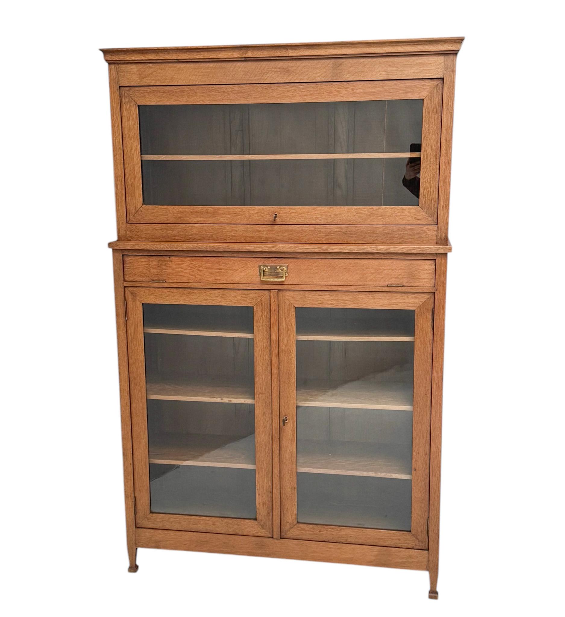 Splendido ed elegante  Libreria a due pezzi in stile Art & Crafts Art Nouveau.
Un sorprendente design olandese degli anni '1900.
Rovere massiccio con vetri originali nelle due porte e nell'anta scorrevole su entrambi i pezzi.
Dietro l'anta a ribalta