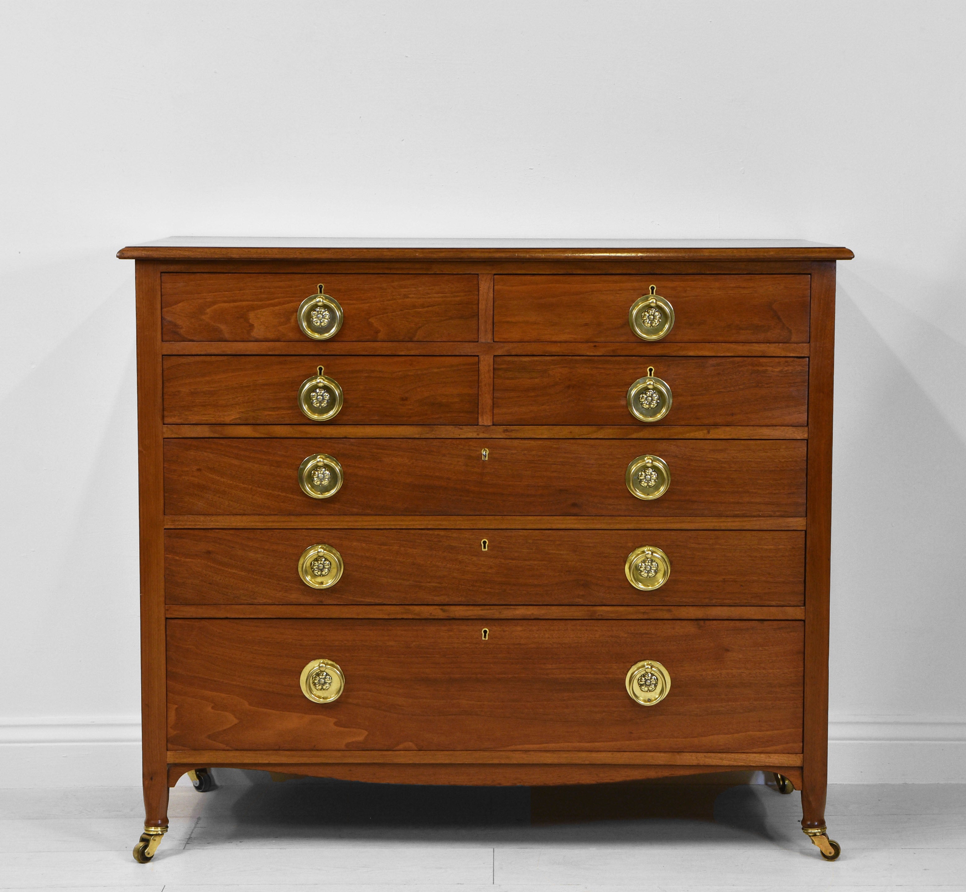 Superb Arts & Crafts figured walnut chest with an unusual arrangement of seven drawers. Original brass poppy-head embossed handles and brass castors. Circa 1900.

An excellent quality chest of drawers which has been sympathetically re-finished by