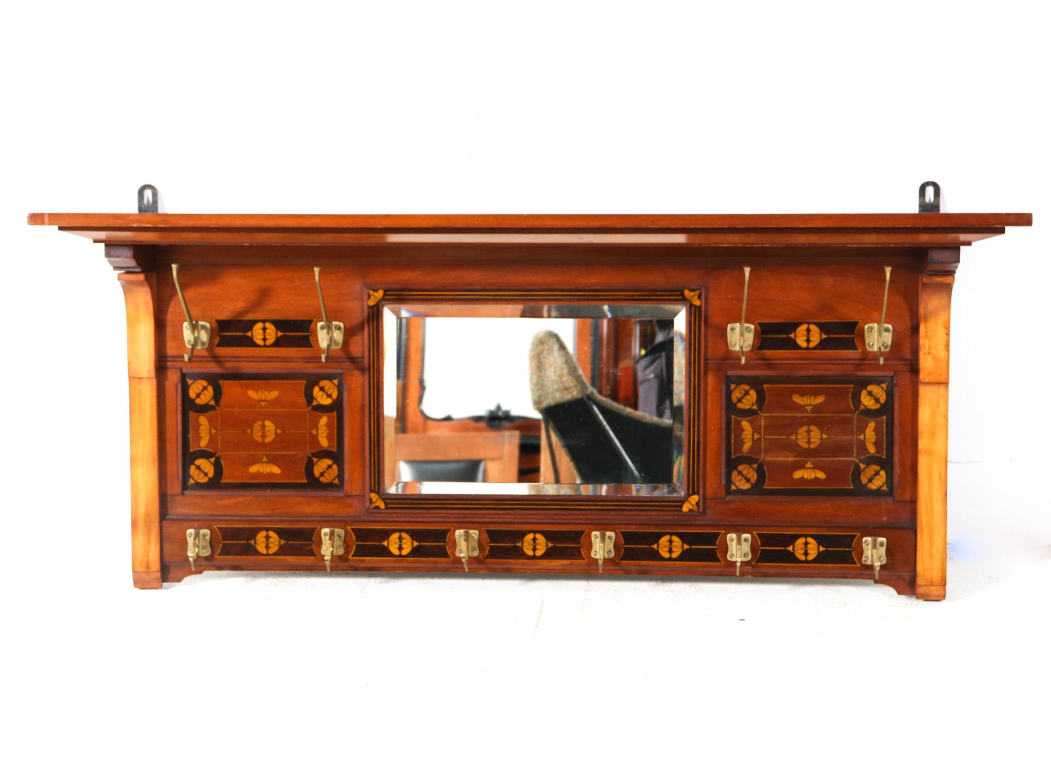 Magnifico e rarissimo appendiabiti Arts & Crafts Art Nouveau.
Un sorprendente design olandese degli anni '1900.
Struttura in noce massiccio con decorazioni originali intagliate a mano.
Dieci ganci originali in ottone patinato e specchio originale