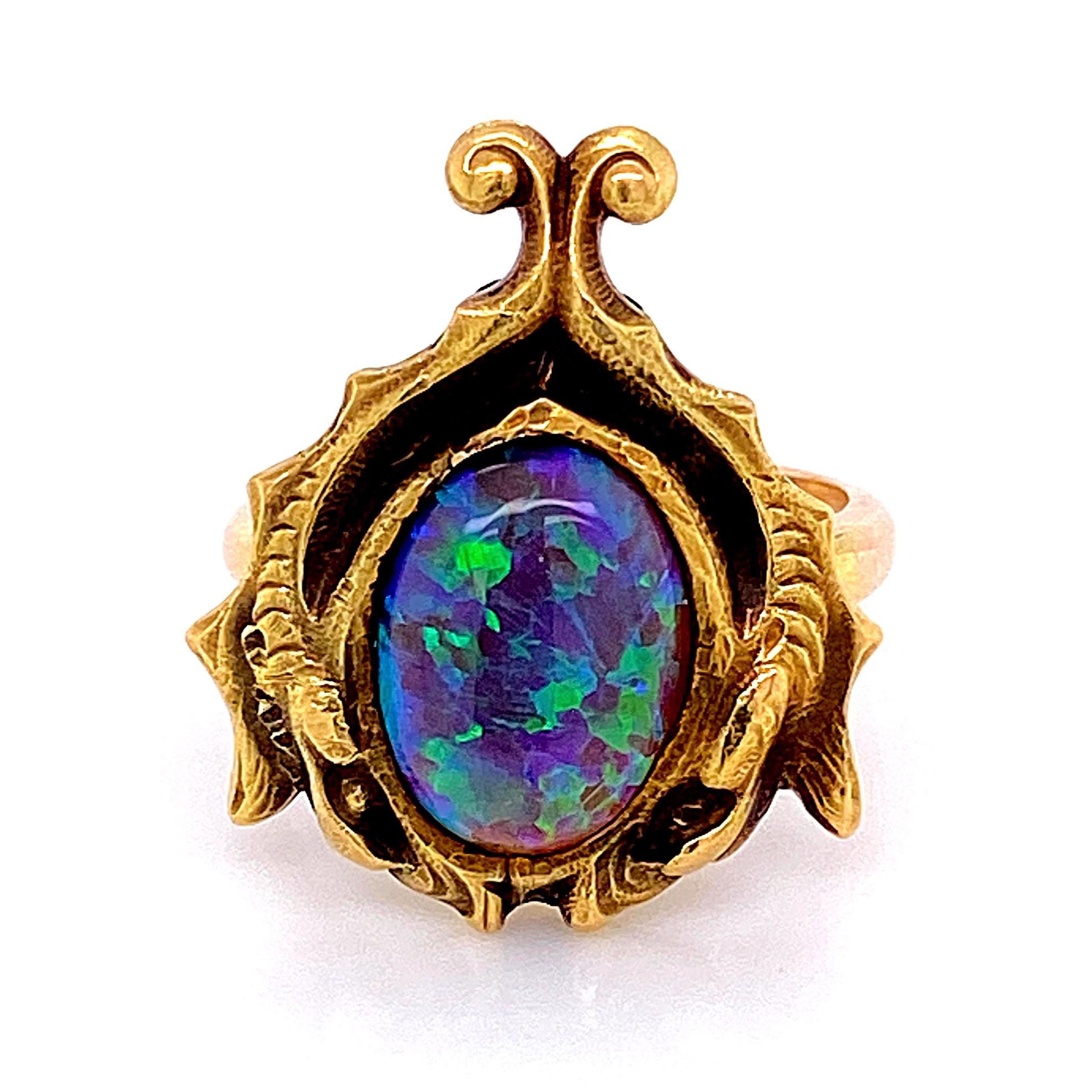 Amazing and Simply Beautiful Cocktail Ring, securely set with a blue-green Australian Lightning Ridge Black Opal in a finely detailed period correct 1930s, 18 Karat Gold Hand crafted mounting featuring abstract leaves shaped like wings.  Size 6, we