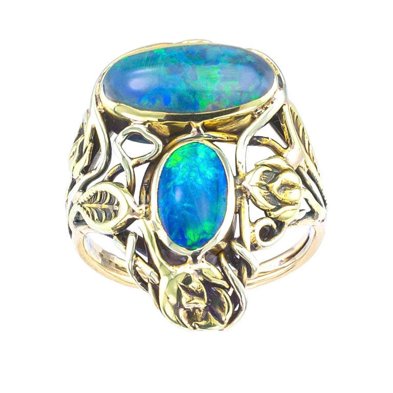 Arts & Crafts black opal and yellow gold ring circa 1900.

DETAILS:
Arts & Crafts black opal and gold ring.
GEMSTONES: two oval-shaped black opals. 
METAL: 14-karat yellow gold.
RING SIZE: approximately 4 ¼.
MEASUREMENTS: approximately 7/8” (2.2 cm)