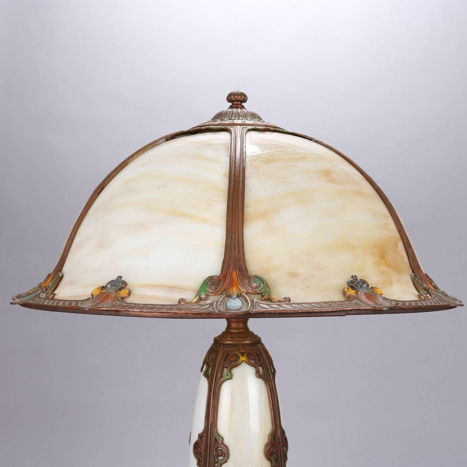 Arts & Crafts Bradley and Hubbard School table lamp features conical form double light base with cast bronze scroll and foliate filigree frame and slag glass and having polychromed highlights, matching six panel bent slag glass dome shade, lights