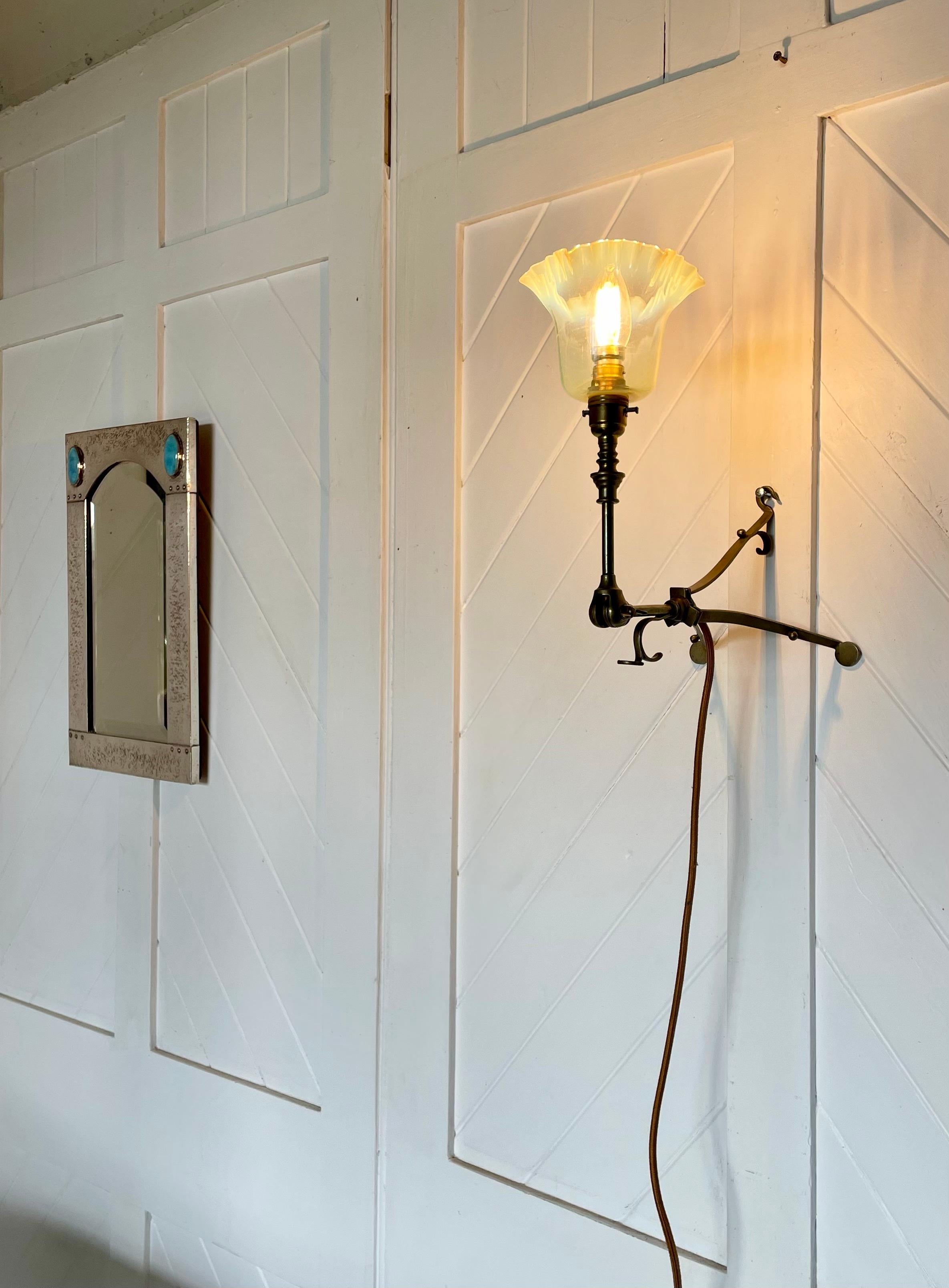 Semplice lampada da tavolo e da parete di Arts and Crafts, struttura angolare a 3 gambe in ottone regolabile con fissaggio a parete per illuminare o abbassare la luce, ideale come lampada da comodino. Paralume in vetro di vaselina.

 Circa