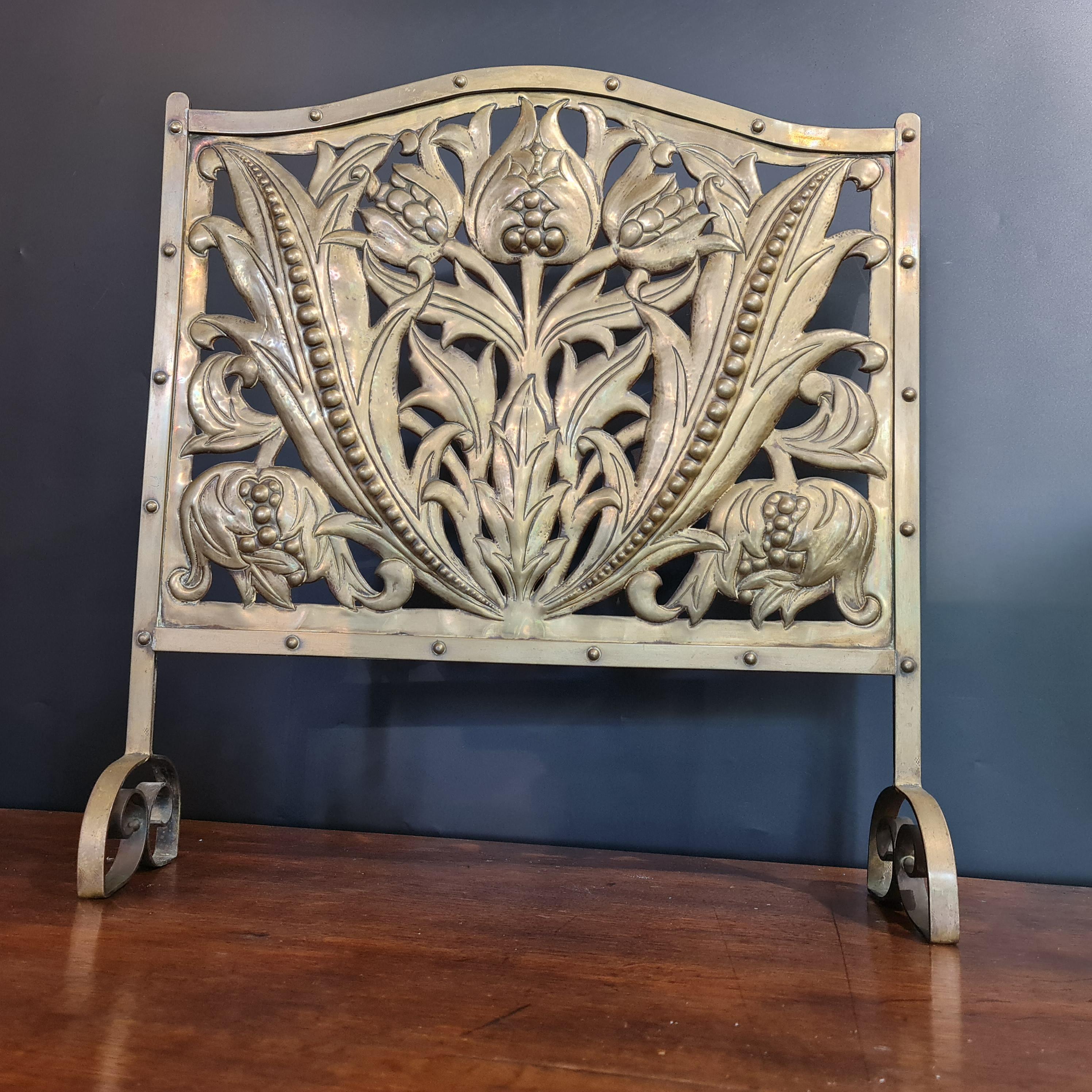 Pantalla de chimenea de latón finamente trabajada Arts and Crafts vendida al por menor por Liberty & Co circa 1900  El diseño de la pantalla se atribuye a John Williams y probablemente fue realizado por The Fivemiletown Class en Irlanda.