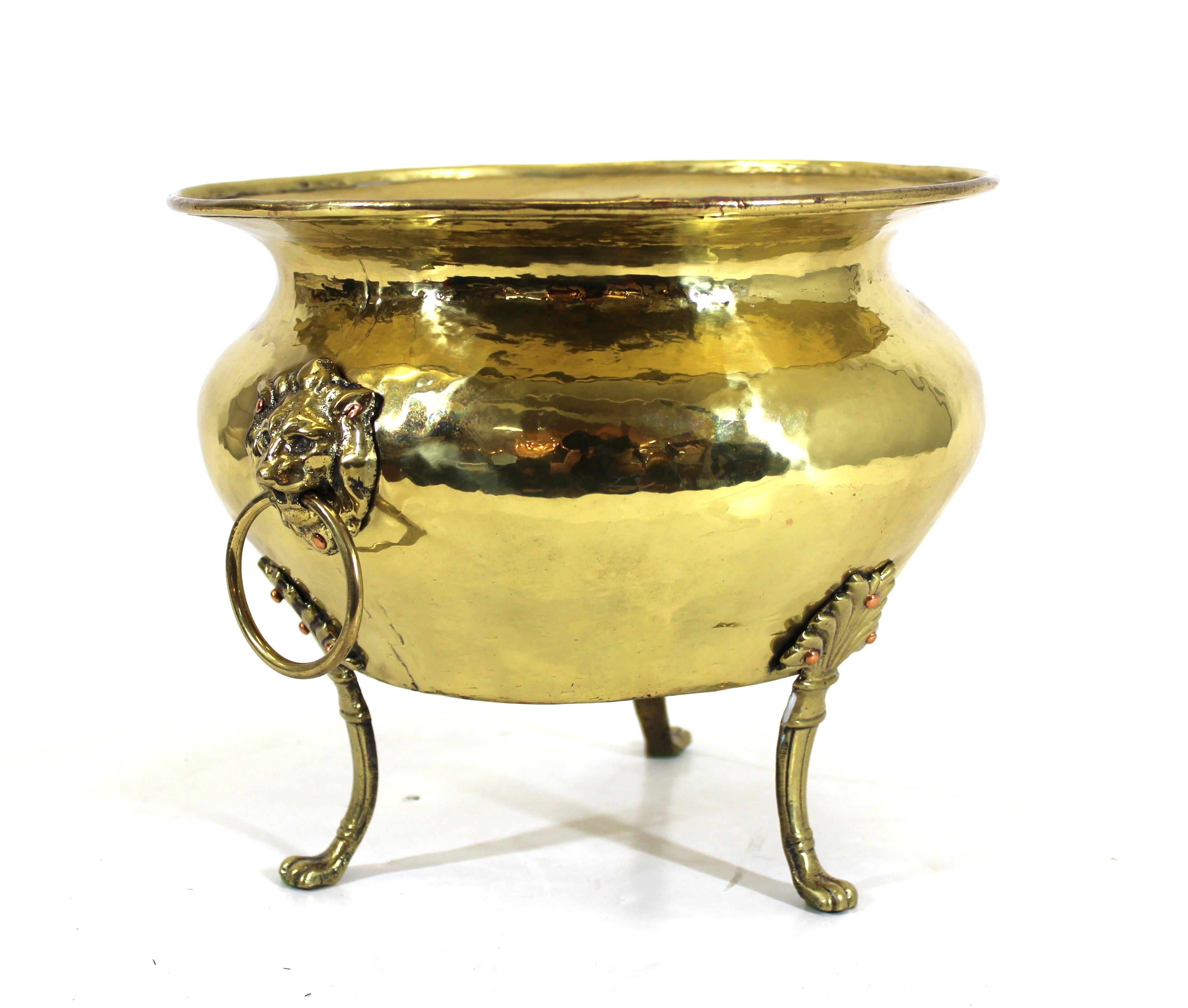 Arts and Crafts antique brass jardinière or planter with lion head handles, hand hammered with seams. Made in Russia in the 1910s, with Russian makers mark embossed to the bottom. In very good vintage condition.