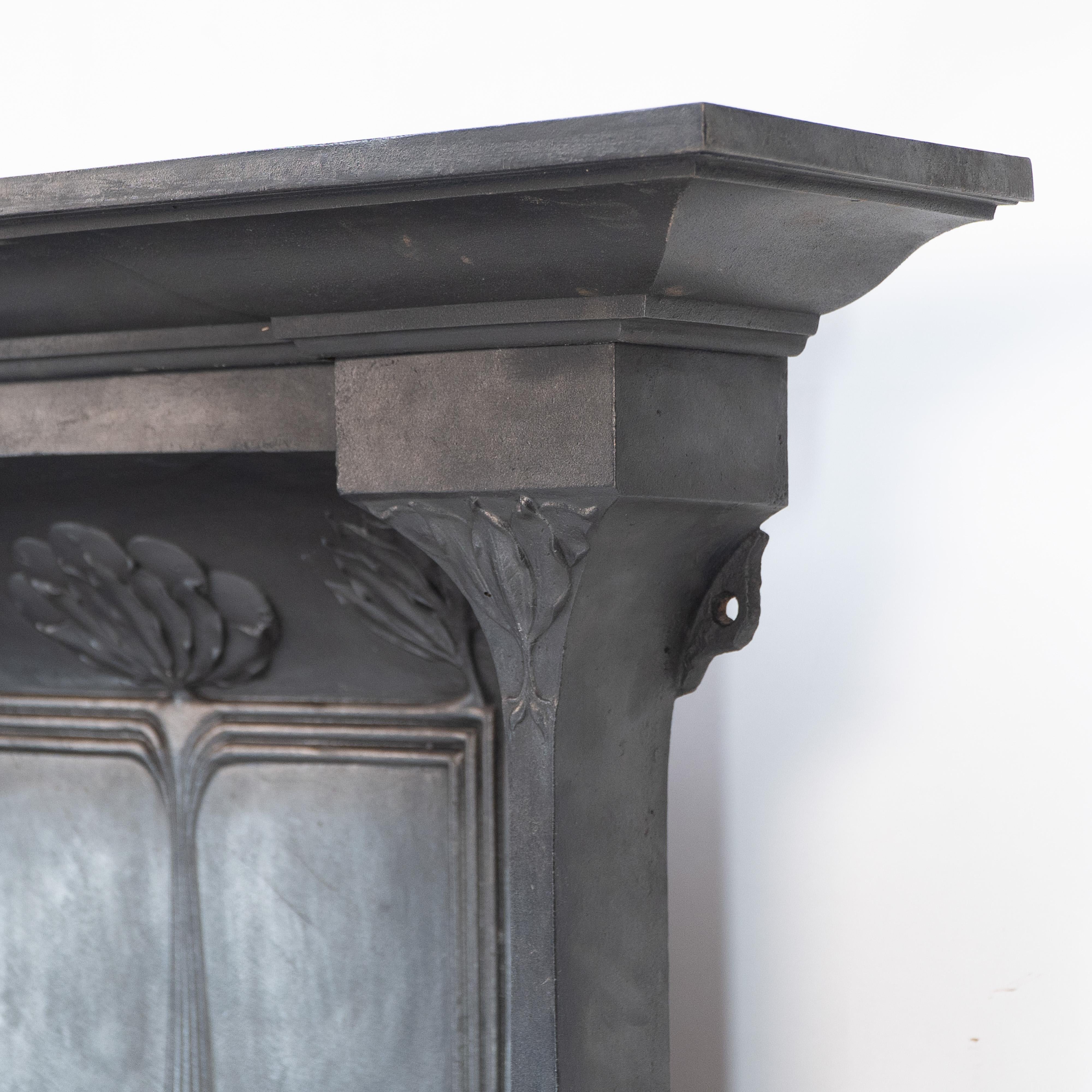 English Arts & Crafts cast iron fireplace with curved sides & stylized floral decoration For Sale