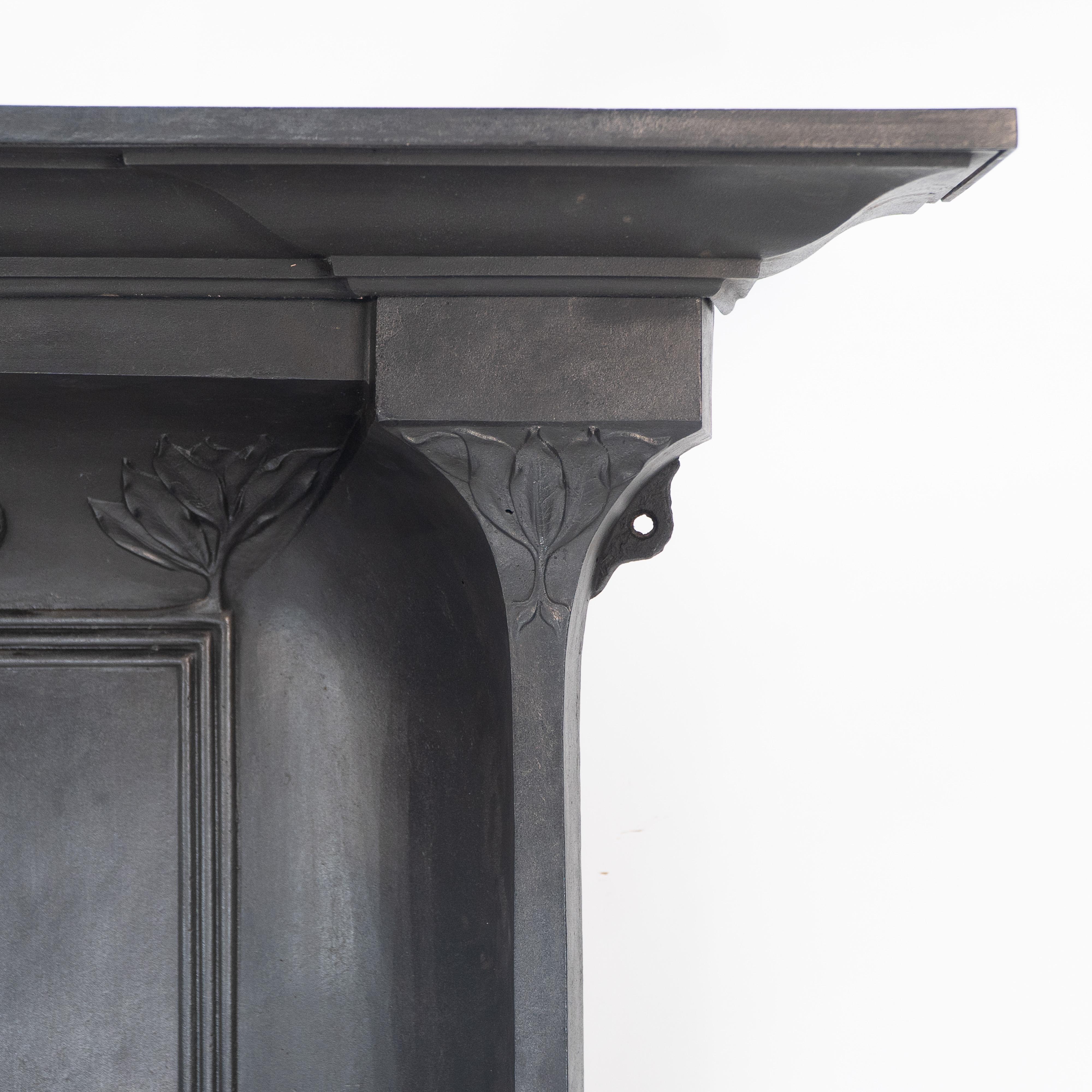 Cast Arts & Crafts cast iron fireplace with curved sides & stylized floral decoration For Sale