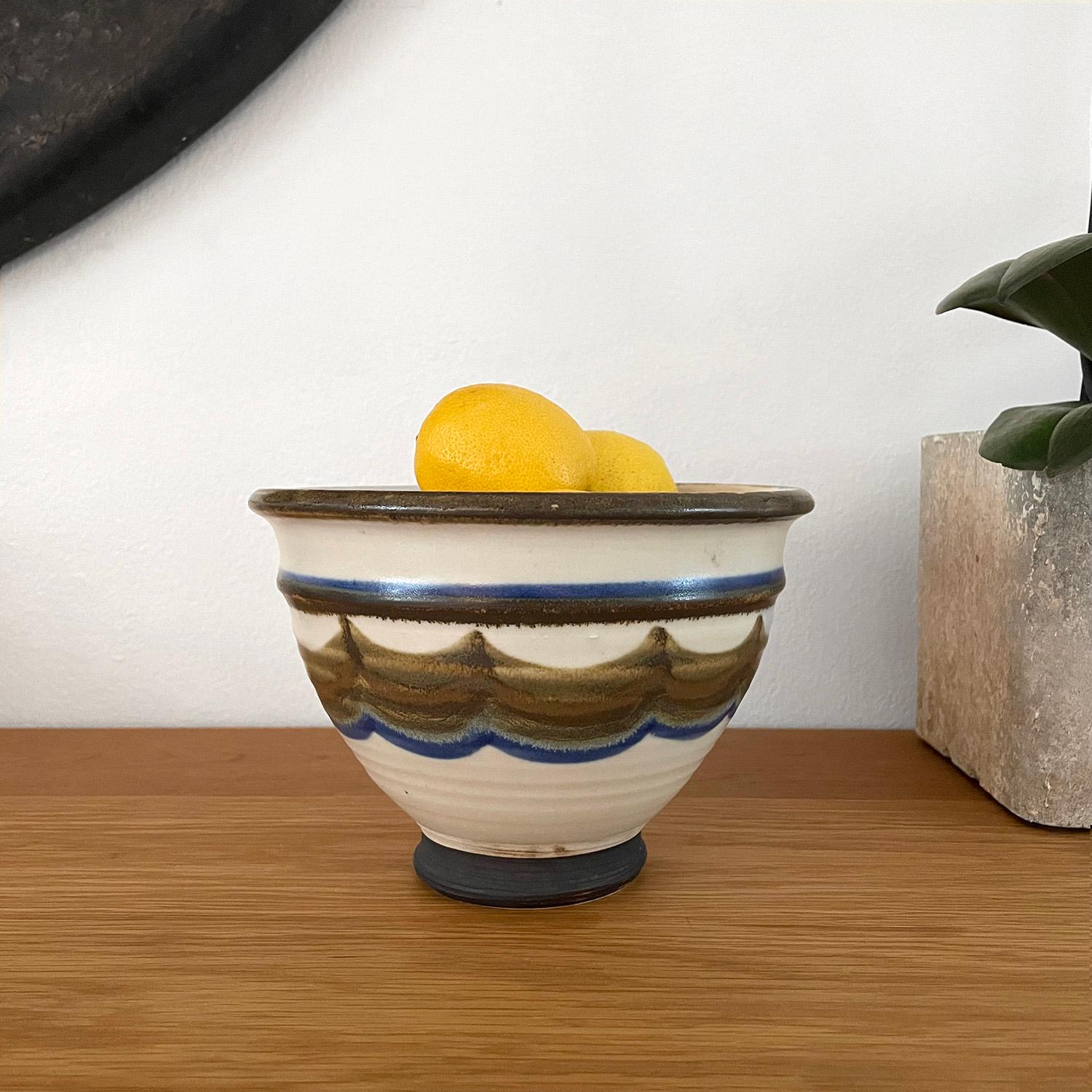 Arts & Crafts ceramic footed bowl
Organic composition and feel
Neutral toned palette
Multi layered wave pattern design accented in deep blue, avocado and browns
Satin glazed finish with the exception of the nuanced footed base
A subtly detailed dark