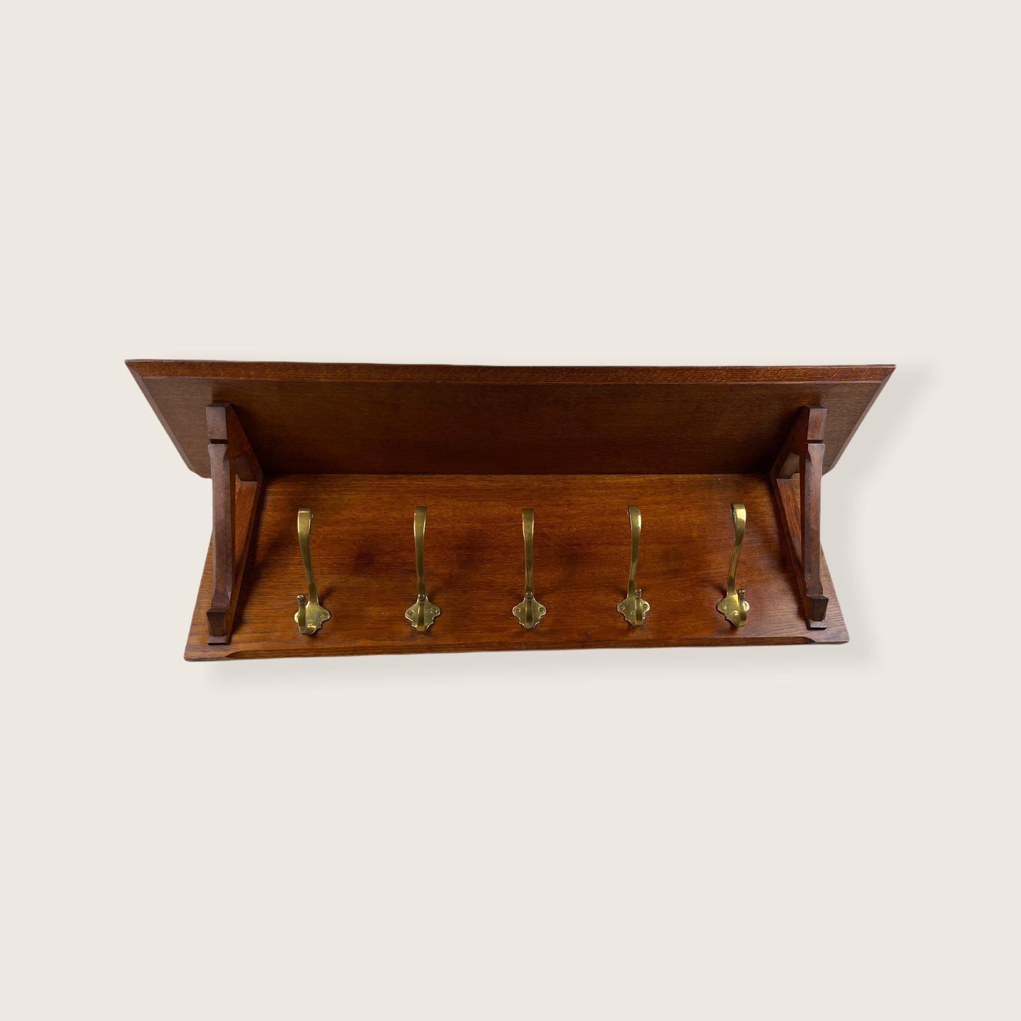 Arts & Crafts coat rack made of oak in England. With the original forged copper hooks. This object is in a good condition but it shows sign of age.