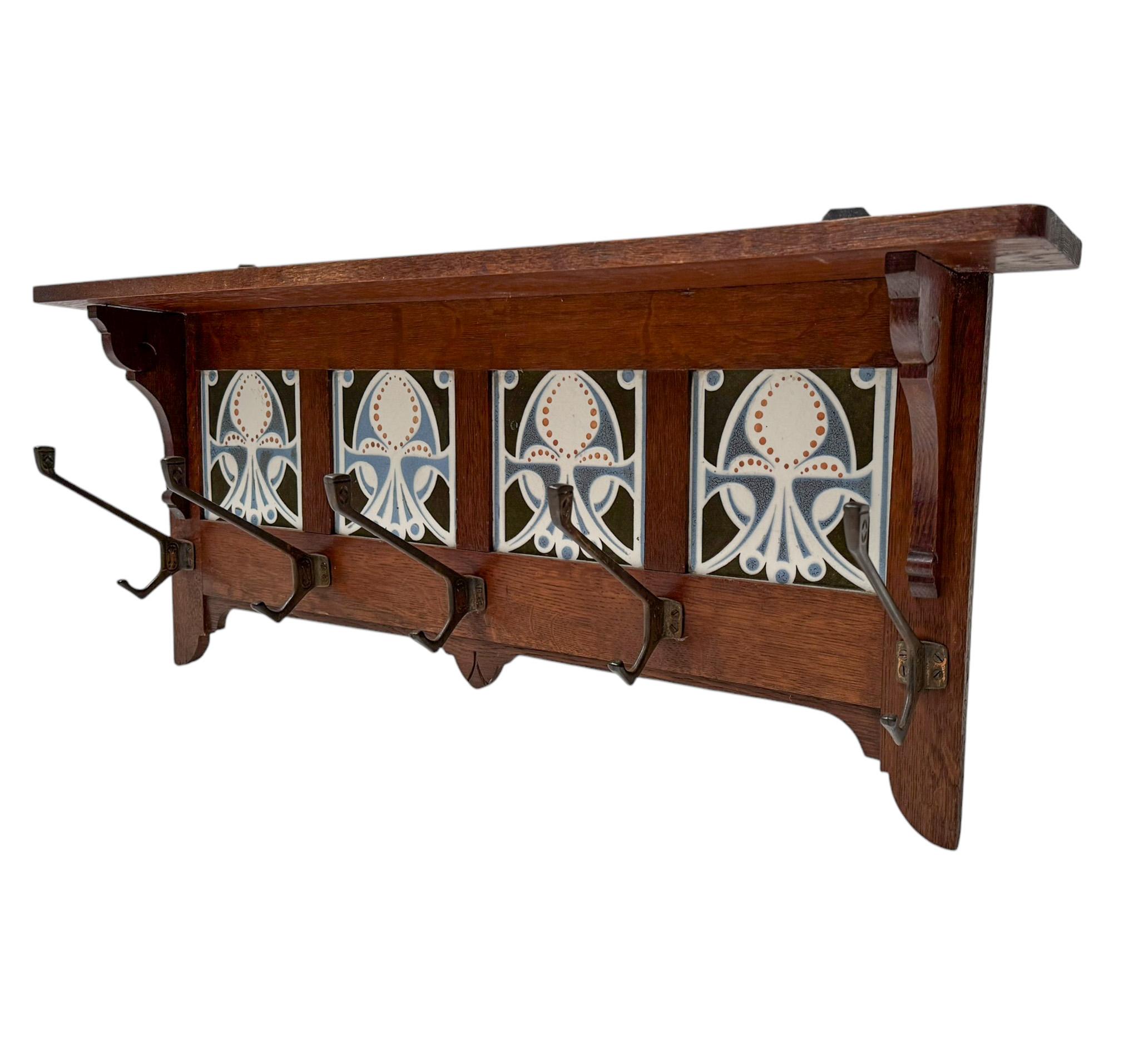 Stunning and elegant Art Nouveau coat rack.
Striking Dutch design from the 1900s.
Solid oak with five original patinated metal hooks.
Four original hand-painted ceramic tiles with decorative elements.
This wonderful Arts & Crafts coat rack is in