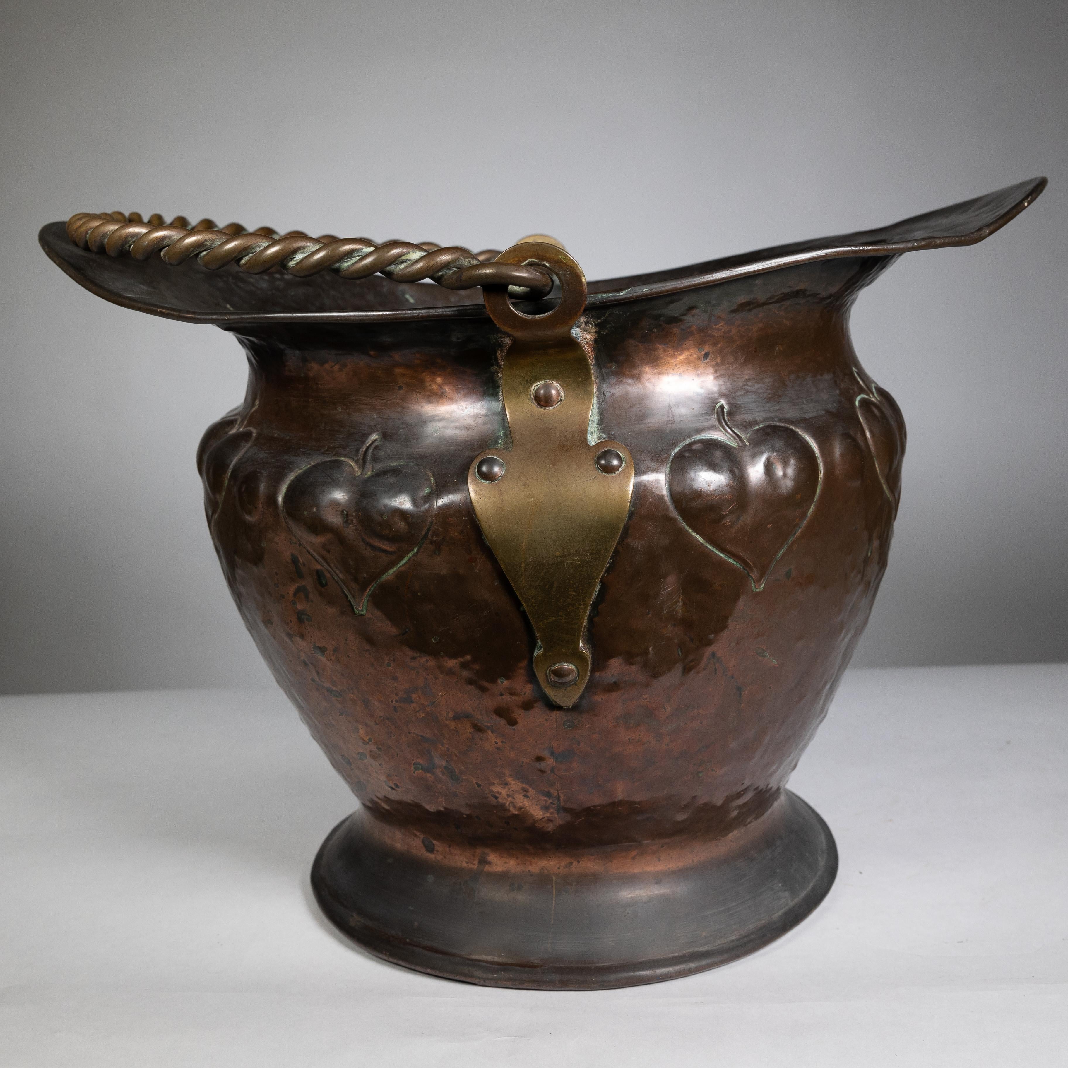 Début du 20ème siècle Copper Craft en cuivre avec décoration en feuilles repoussées et poignée en corde. en vente