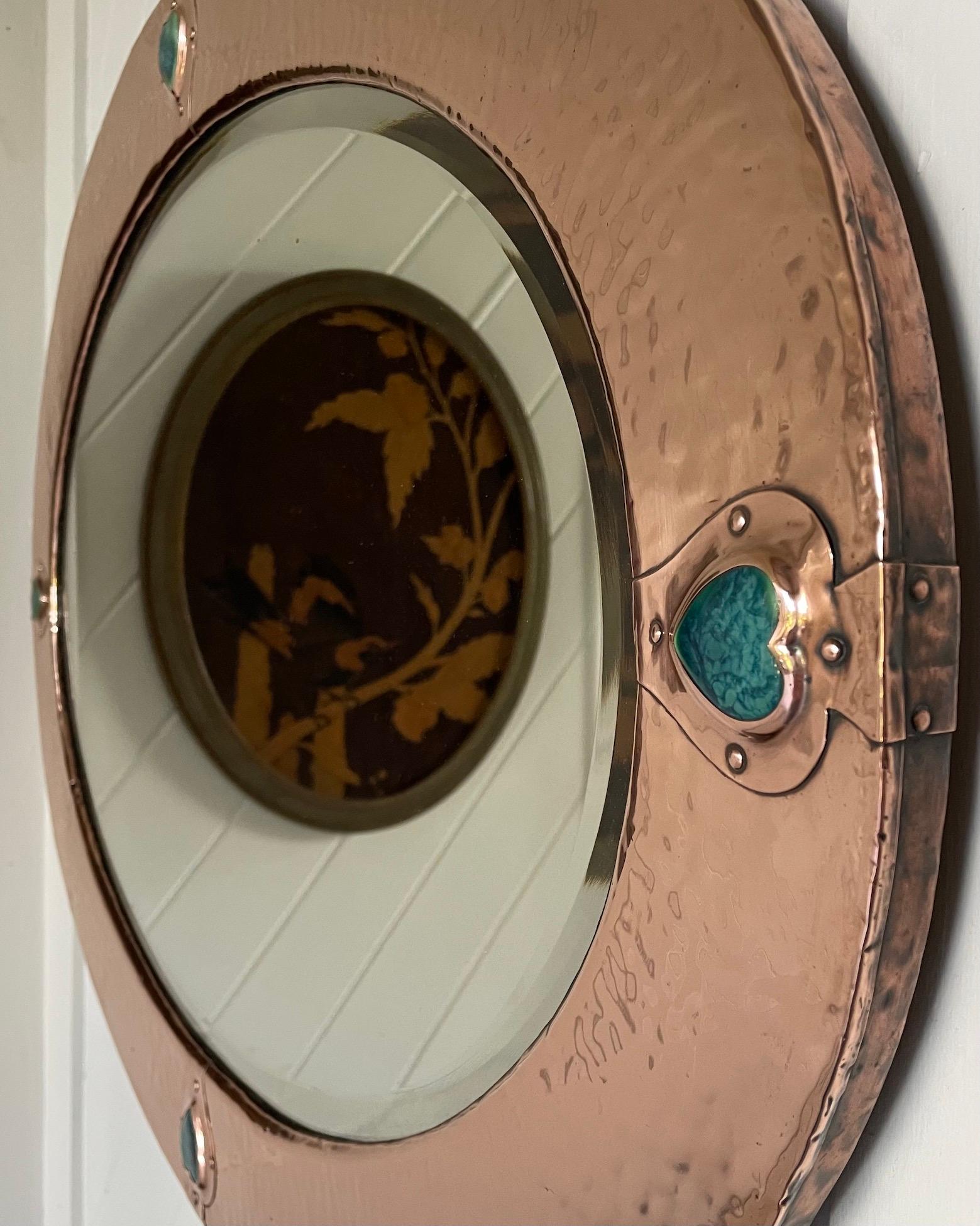 Arts & Crafts copper framed oval mirror
With inset cabochon heart shaped Ruskin panels
Attributed to Liberty & Co
Circa 1900