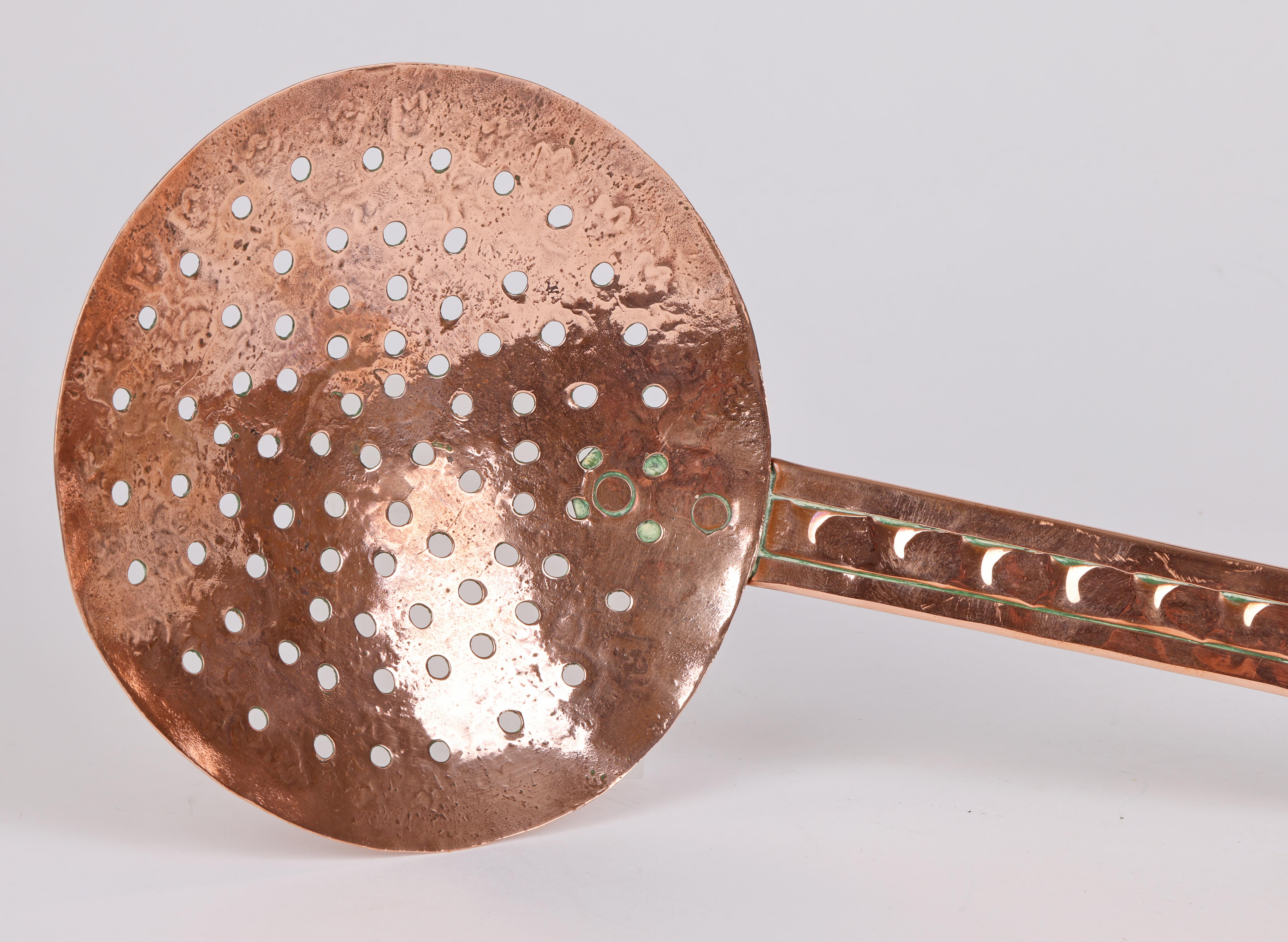 A very stylish Arts & Crafts hand crafted handled copper chestnut roaster dating from around 1890. The chestnut roaster has a hammered and pierced round bowl attached by two copper rivets to a long hammered handle with a folded edge to strengthen