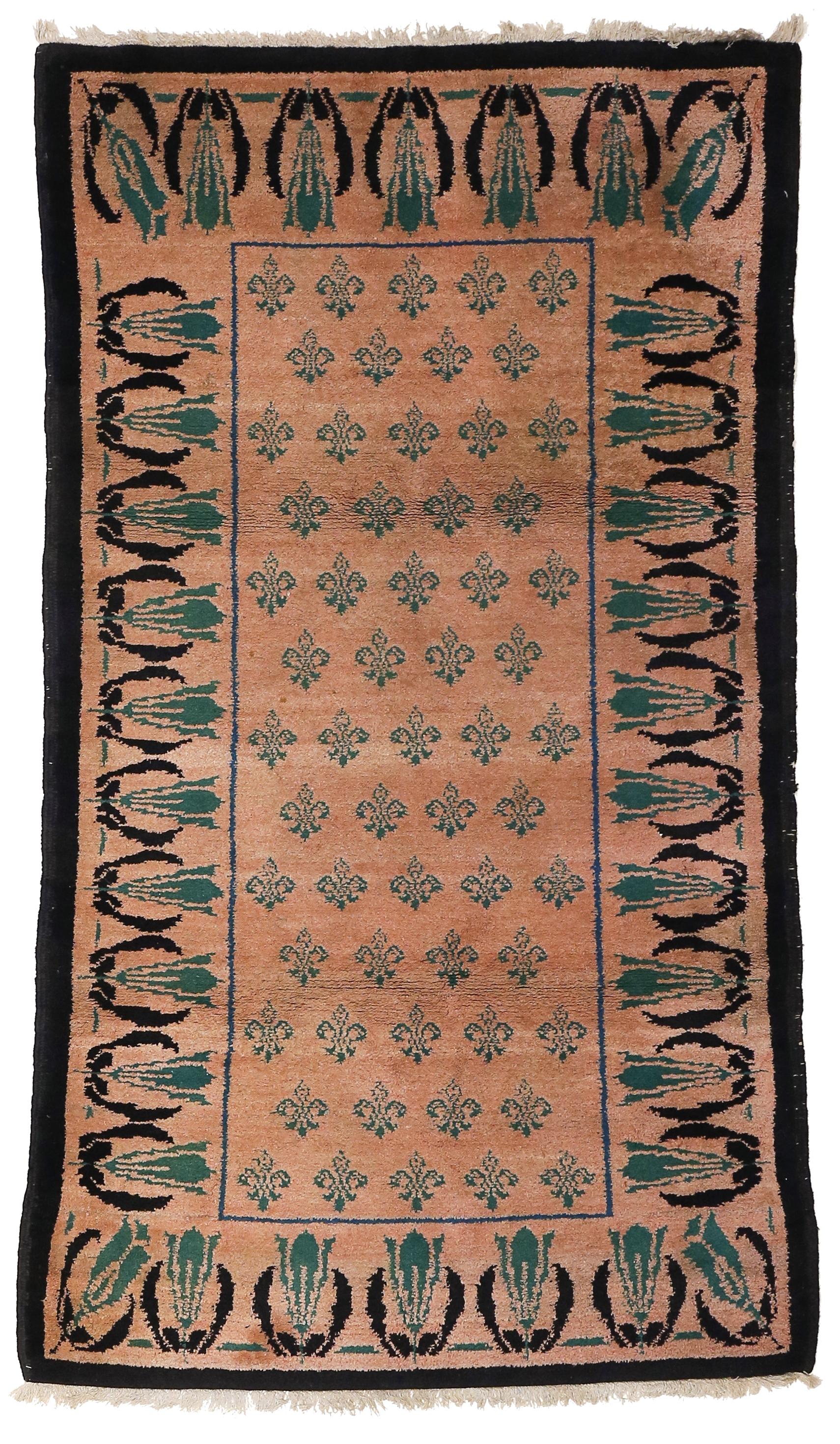 An unusual Arts & Crafts rug, sturdily woven in wool with an all-over pattern of 'fleur-de-lys' and a border of stylized tulips in green on a soft coral background.