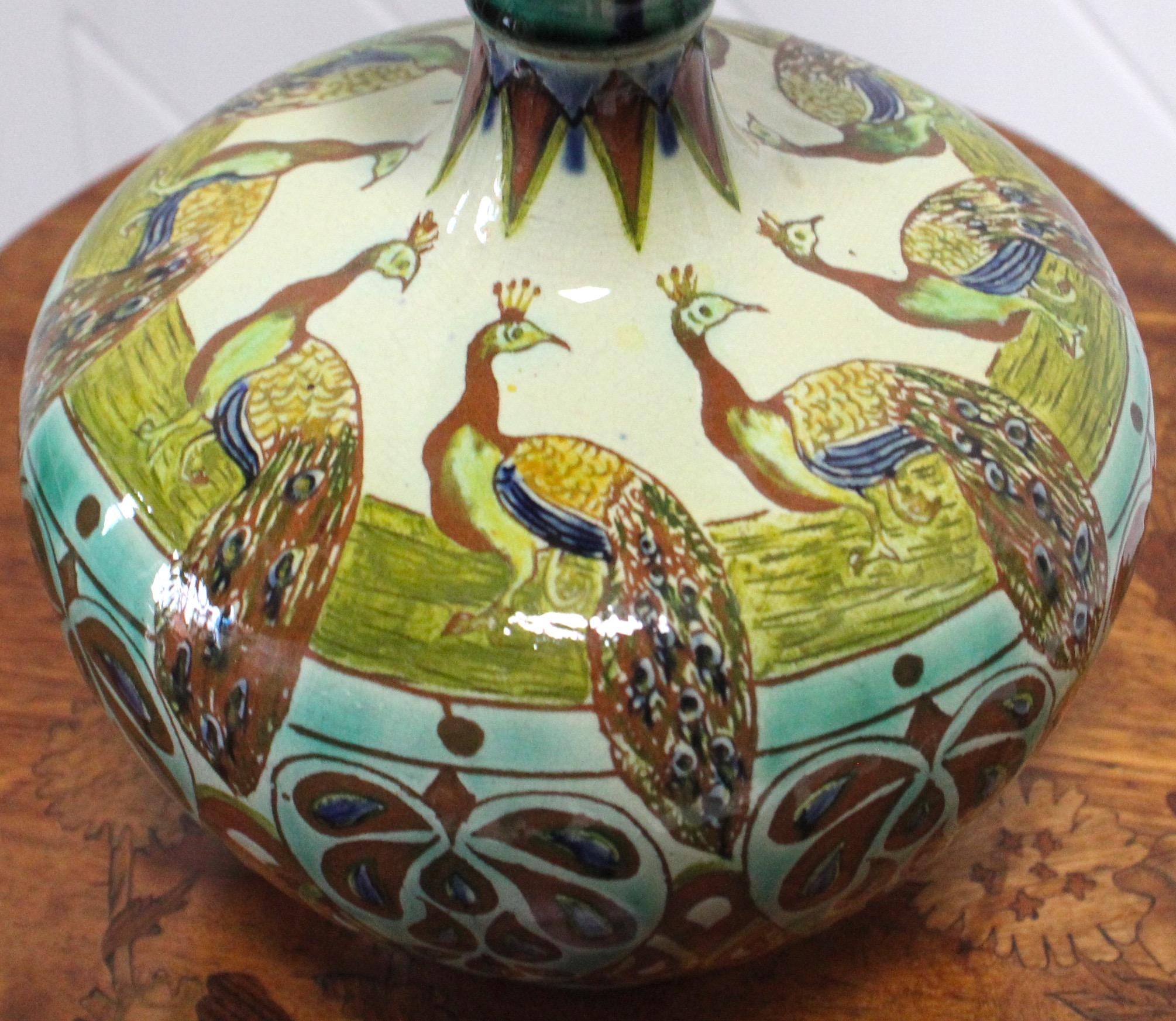 Extremely rare Arts and Crafts Dutch shaped vase with original lid
Depicting peacocks
This vase is Signed JS - probably Jessie Sinclair
It has been coloured by HJ - Hannah Jones
Made by Della Robbia 
Circa 1898
Please see image of the vase