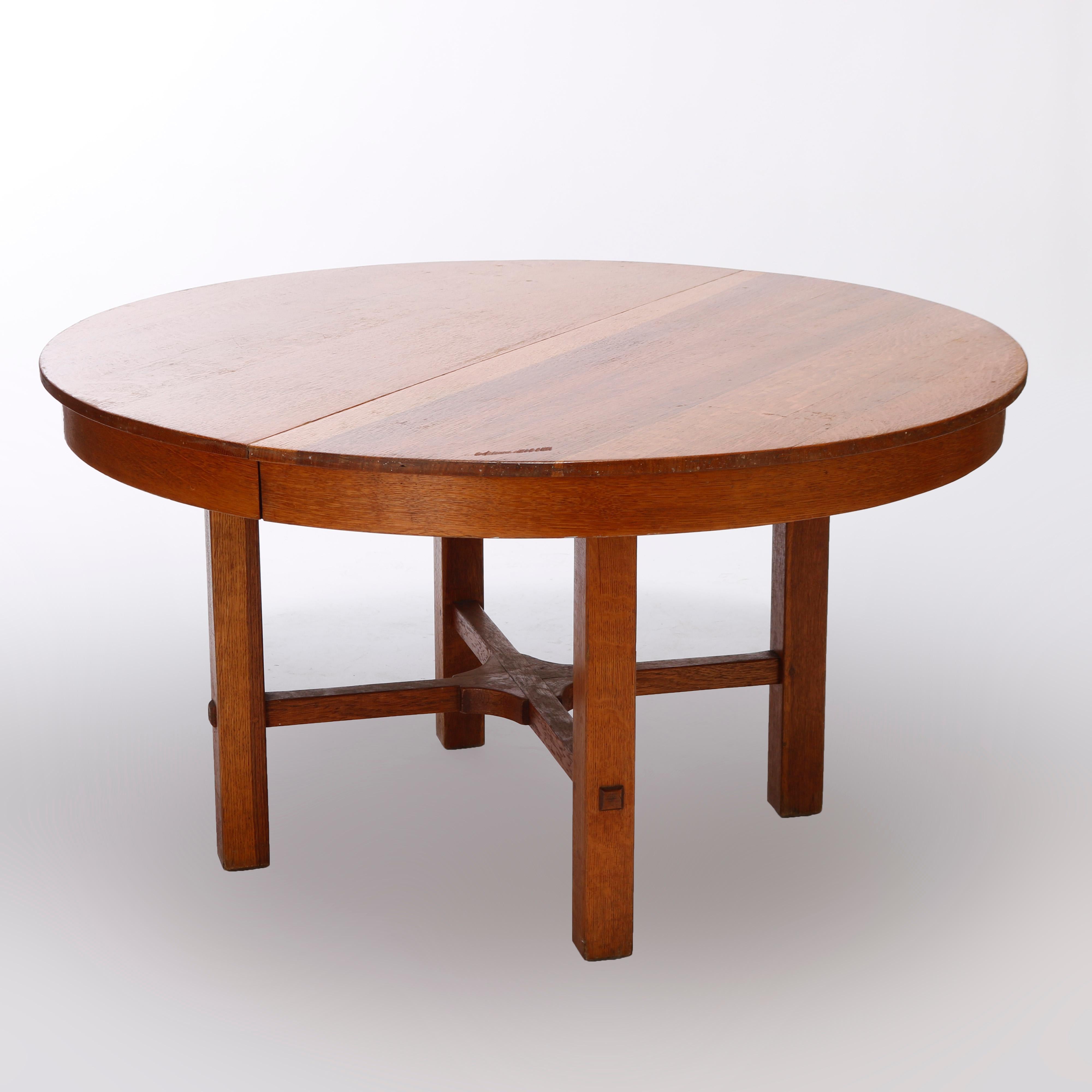 An Arts & Crafts extension dining table, Work of L & JG Stickley, offers oak construction in round form with straight legs having x-form stretcher, extends to accept single leaf, c1950

Measures - 39.75'' H x 54.25'' W x 54.25'' D.