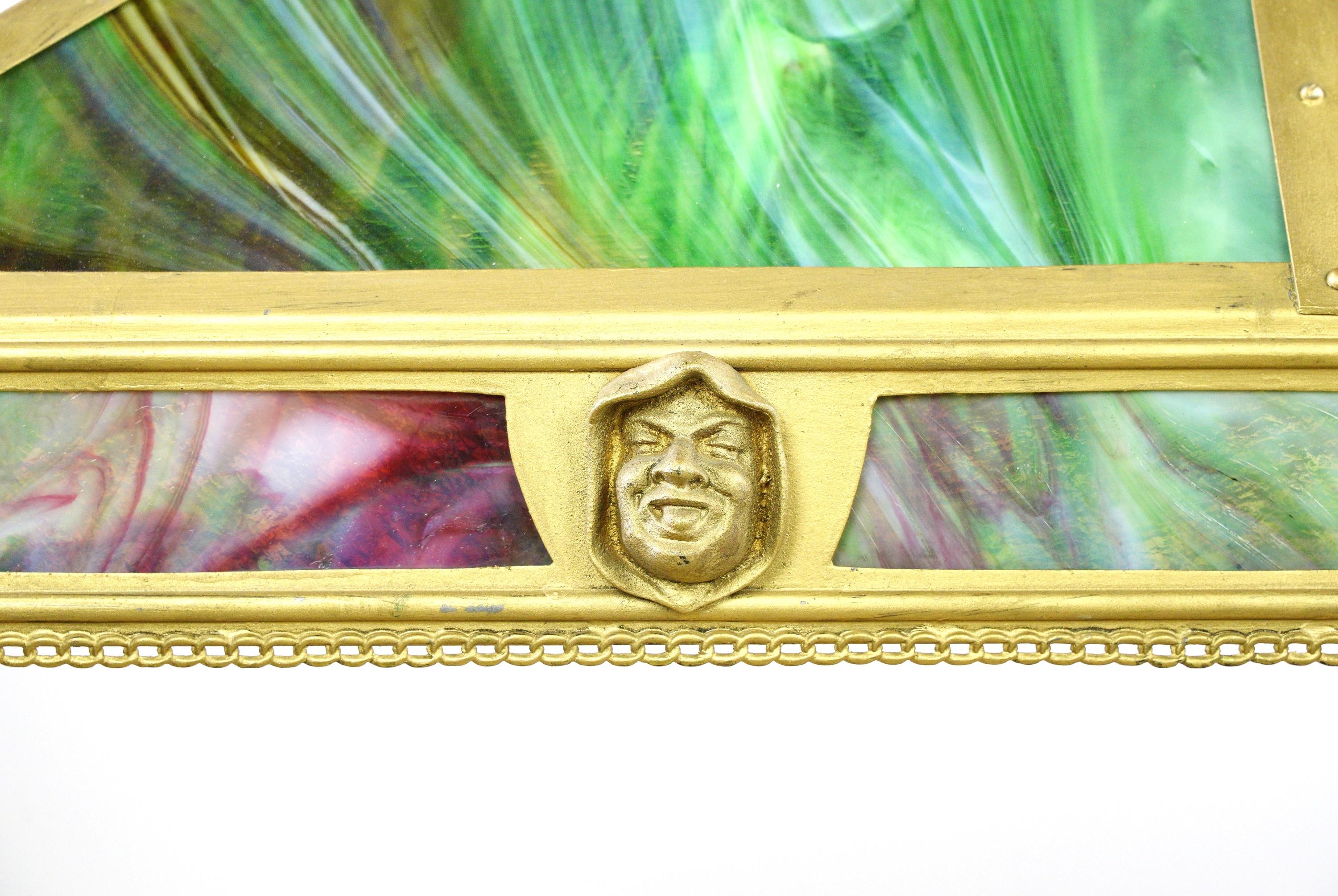 Realizzato con una cornice rettangolare in ottone, presenta bellissimi pannelli in vetro colorato con motivi figurativi. Questa lampada a sospensione racchiude i principi del movimento Arts and Crafts, enfatizzando l'artigianato e i dettagli