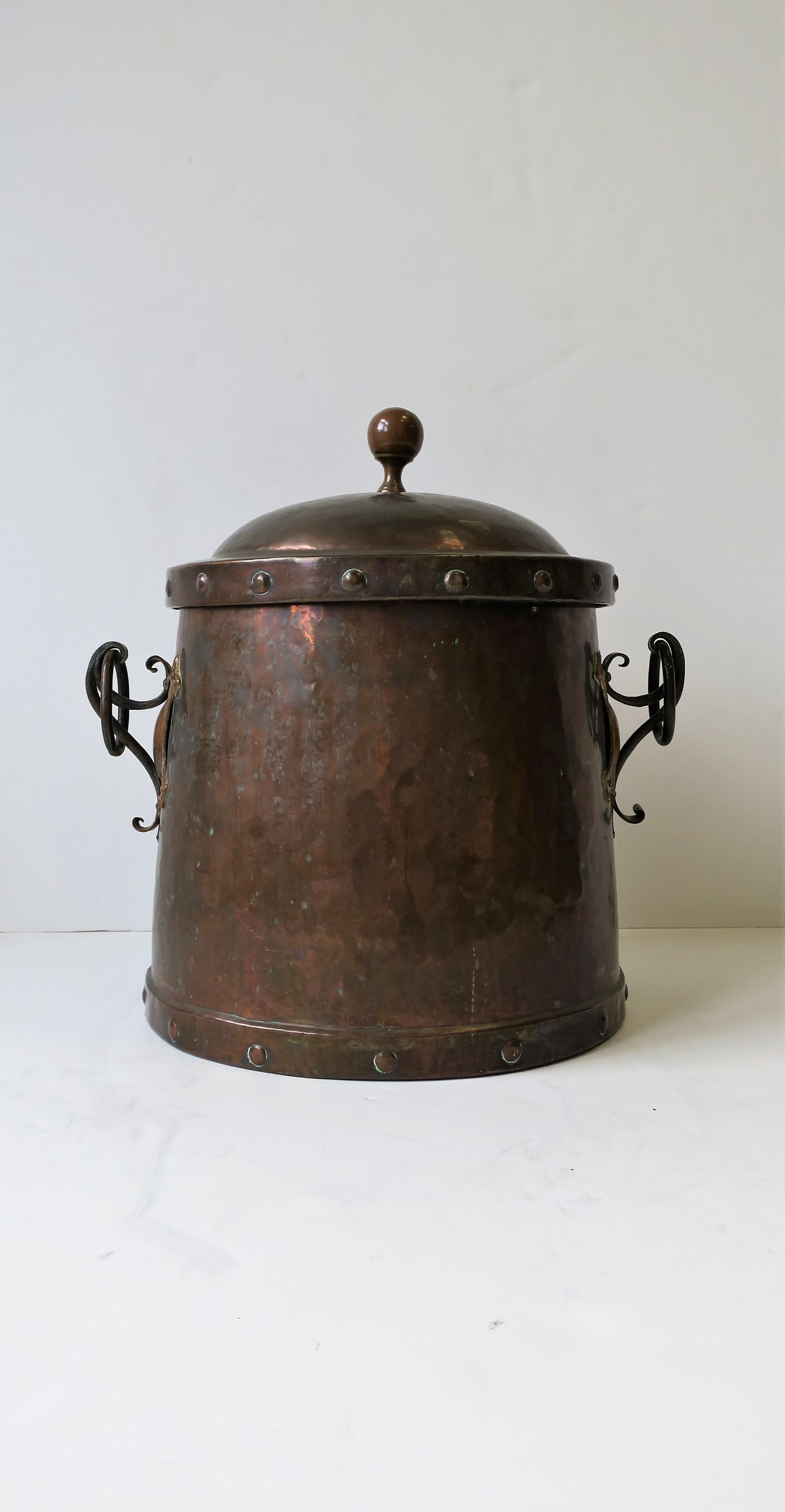 A beautiful and substantial Arts & Crafts large copper and bronze fireplace chimney pot with cover. Pot/bucket has rivet design and round finial top, beautiful medieval detail, rivet base design, and oval ring handles. All hand hammered with