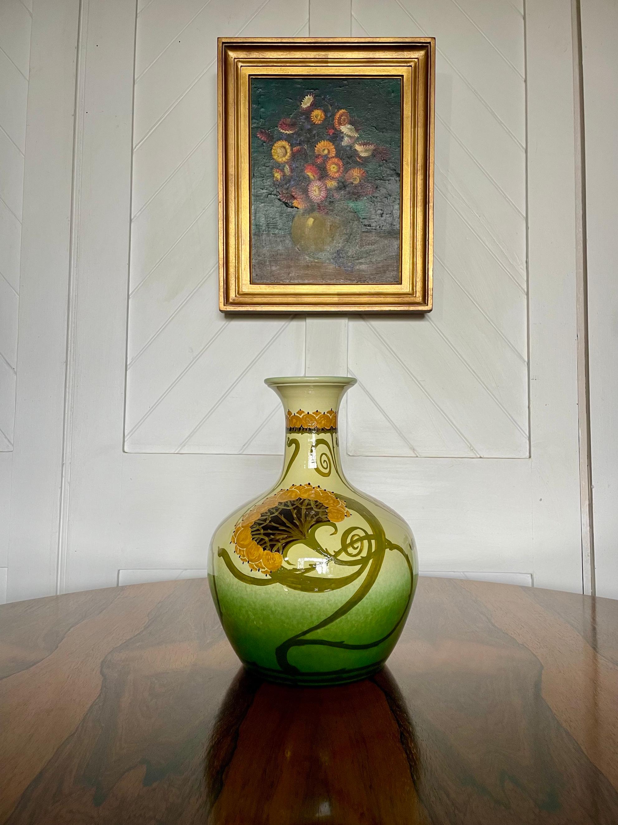 Vase en poterie Arts & Crafts avec détails floraux décoratifs

Faïence émaillée et peinte 

Intérieur bleu et base verte

Conçu par Clarissa Ault

Pour Ault Pottery 

Circa 1890

Hauteur 33 cm.  Diamètre 23cm 

William Ault (1842-1929) a travaillé