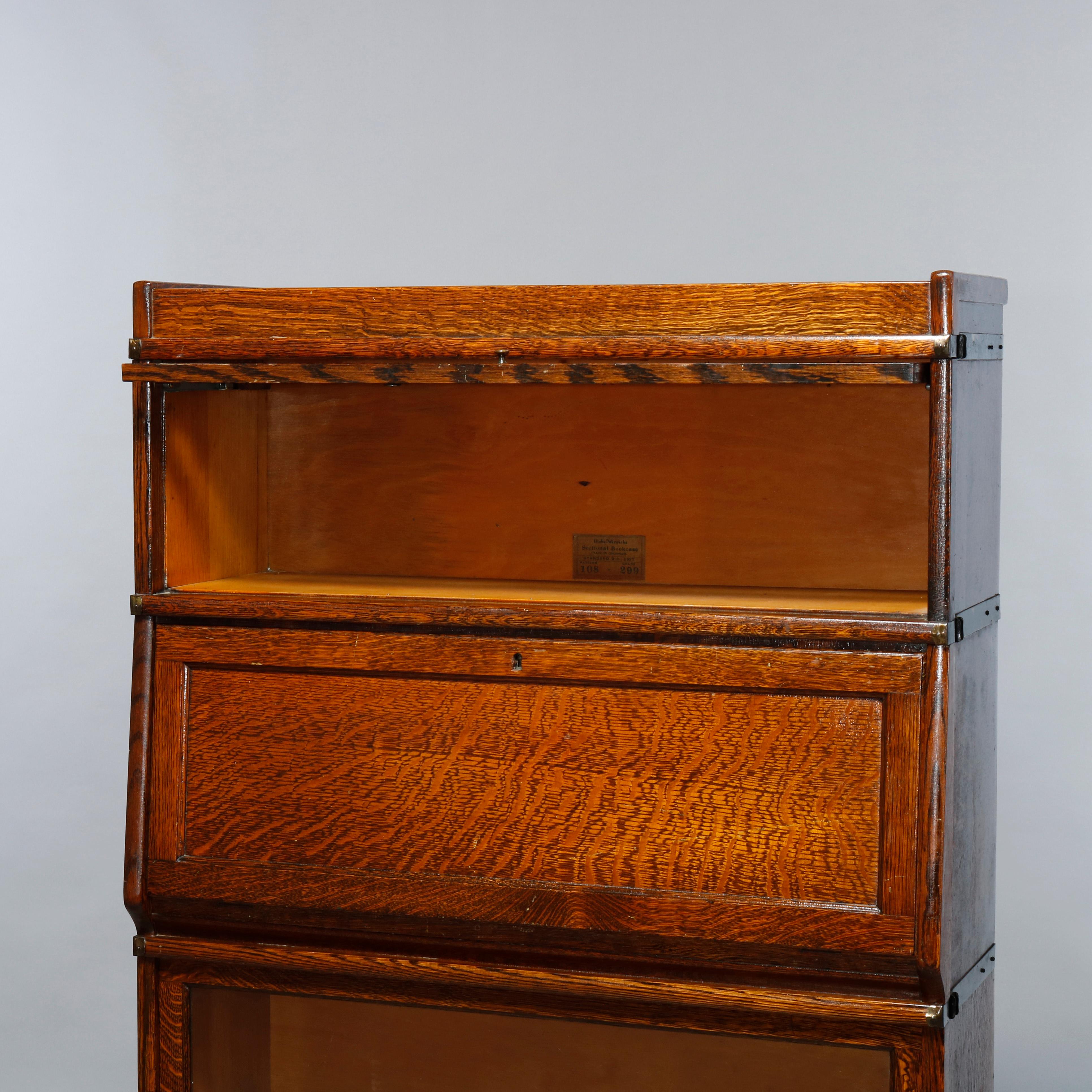An antique Arts and Crafts secretary by Globe Wernicke offers oak construction with barrister cases having glass doors and drop front desk, original labels as photographed, circa 1890 

Measures: 60 