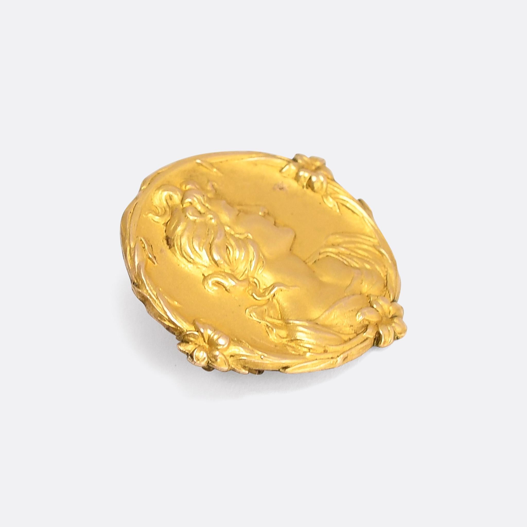 An exquisite Arts & Crafts movement brooch made in England in the turn of the 20th century. The style is unmistakably Pre Rafaelite inspired, featuring a finely detailed floral and foliate border, realistic (if not perhaps a little idealised) hair,