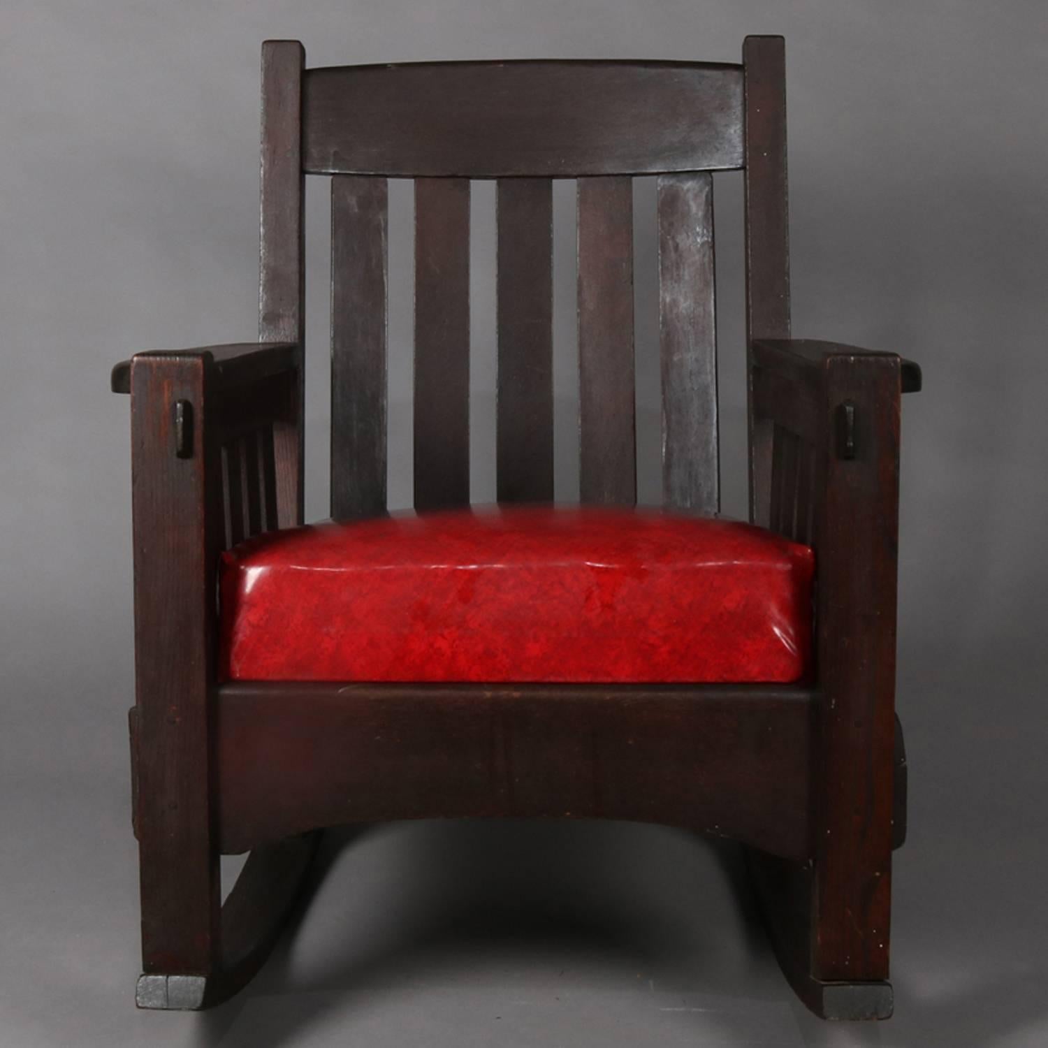 Antique Arts & Crafts mission oak Gustav Stickley school rocker by Harden Furniture features traditional slat back and arms with thick cushioned seat, circa 1910

Measures: 35