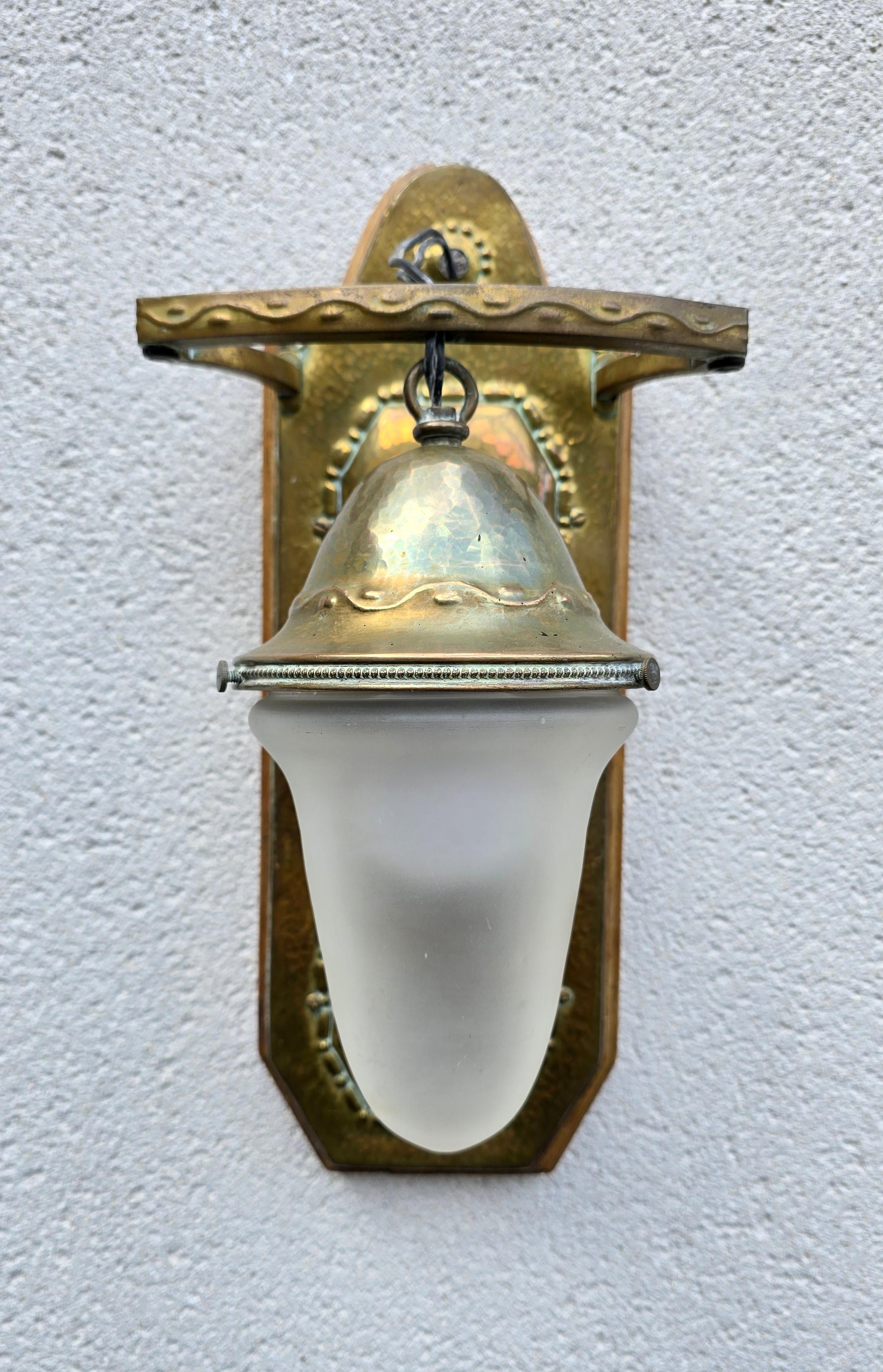 Un'applique finemente realizzata a mano in ottone martellato con paralume in vetro smerigliato, circa 1920.

Elegante lampada da parete Arts & Crafts dei primi del Novecento, realizzata a mano in ottone martellato con una calda patina invecchiata.