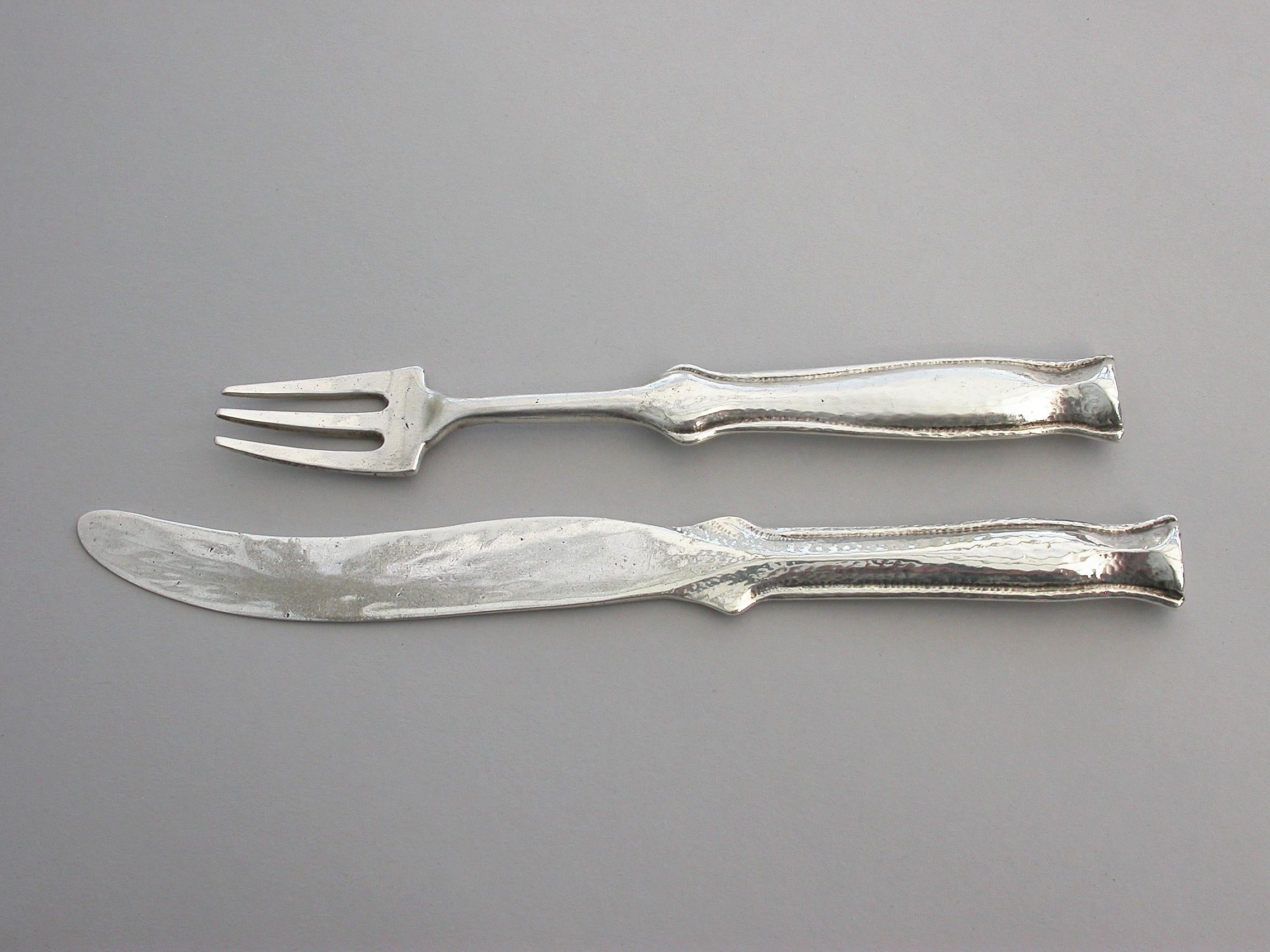 A pair of early 20th century Arts & Crafts silver dessert knife and fork with hammered finish and of a very heavy gauge, the shaped handles with flat nail head finials.

By Ramsden & Carr, London, 1913

Fork 157 mm long
Knife 190mm long

143