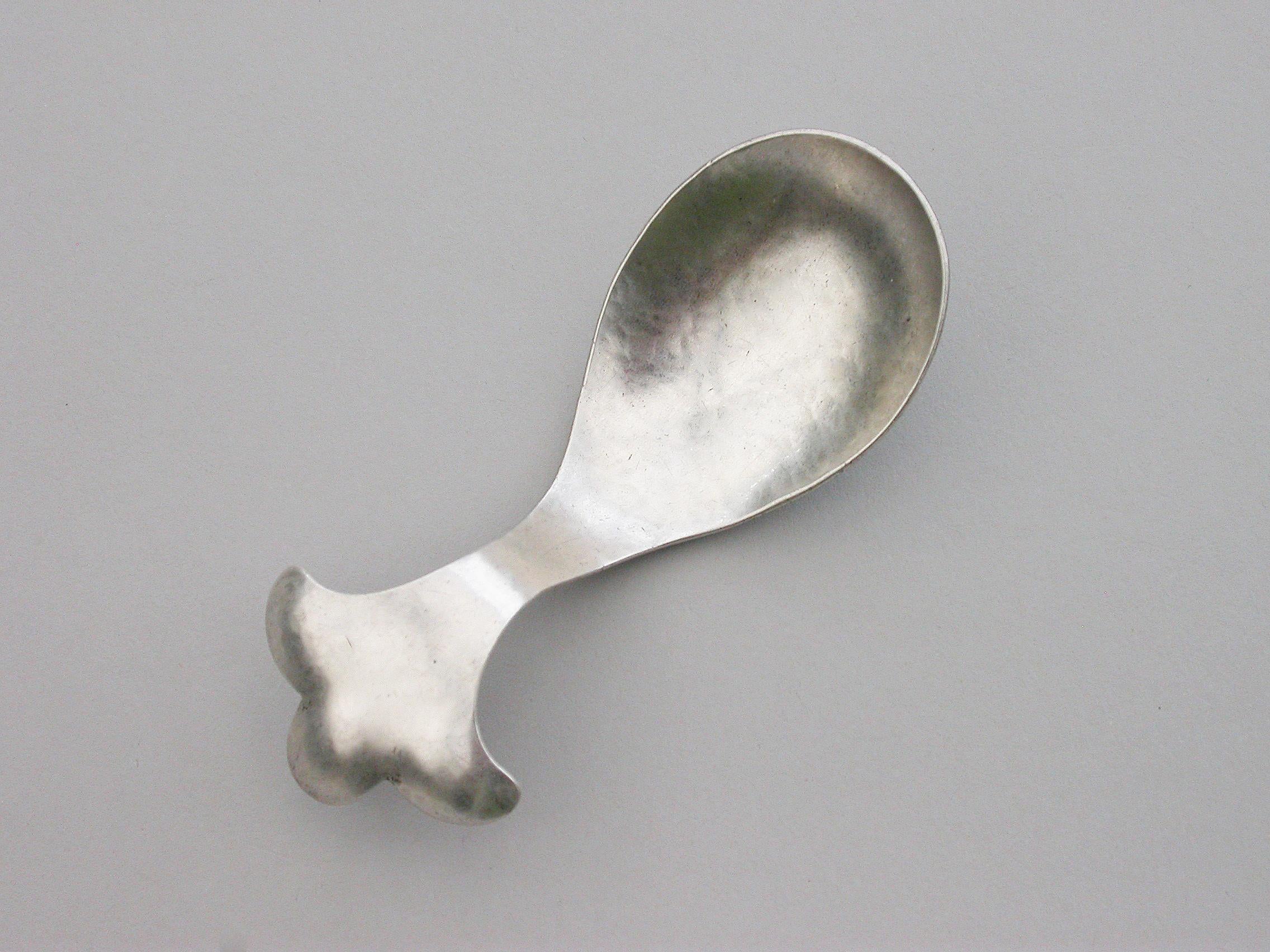 An early 20th century hammered silver caddy spoon made in the Arts & Crafts style, the curved handle with trefoil shaped terminal.

By W T Pavitt, London, 1929.

Weight 20.00 grams (0.64 troy ounces).