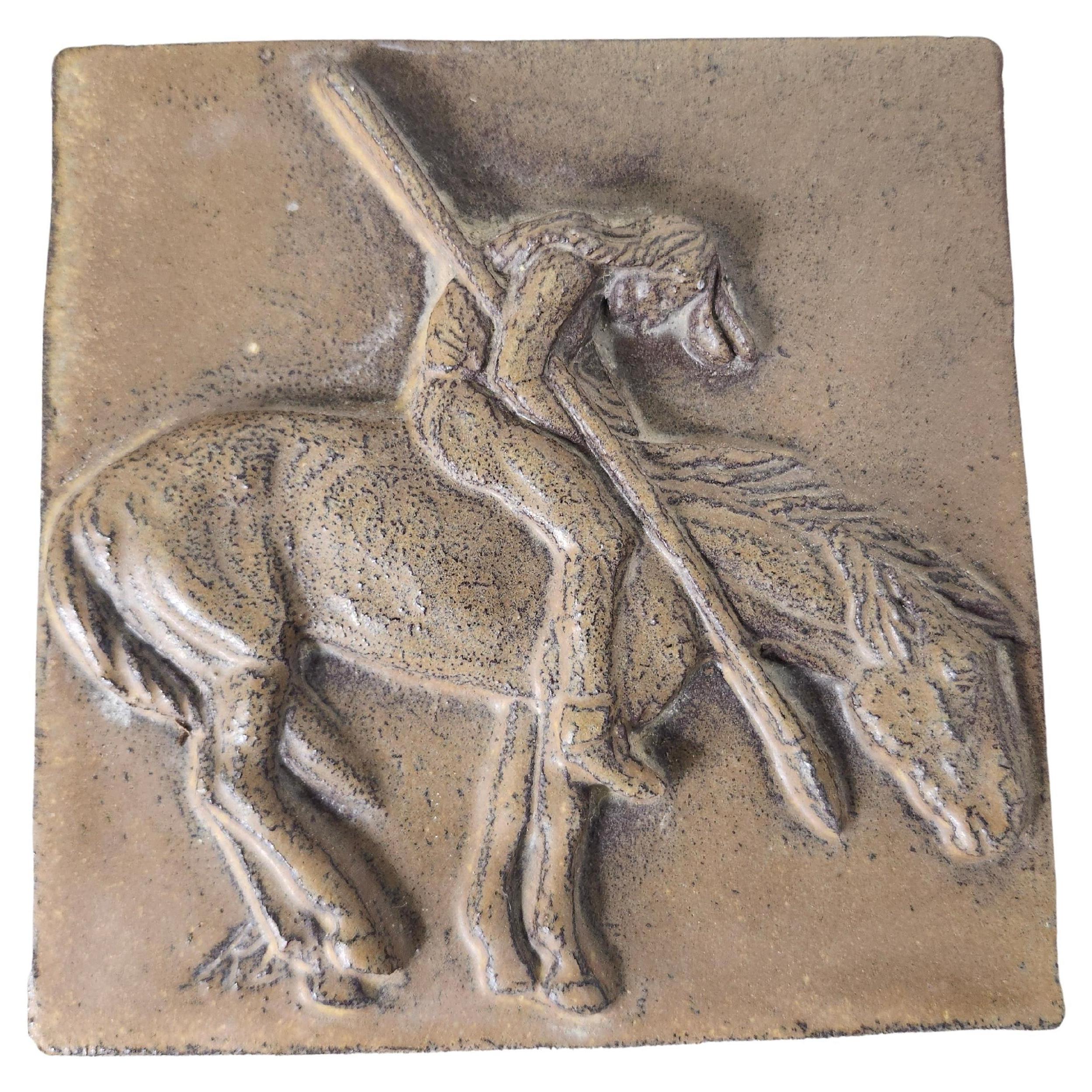 Handgefertigte Kunstfliesen in Eiche gerahmt. Die zentrale Fliese zeigt einen Indianer auf einem Pferd in Ruhestellung. Bronzefarbene Fliese, eingerahmt von 12 quadratischen, blau glasierten Fliesen. Wir hatten den Namen des Künstlers, wissen ihn