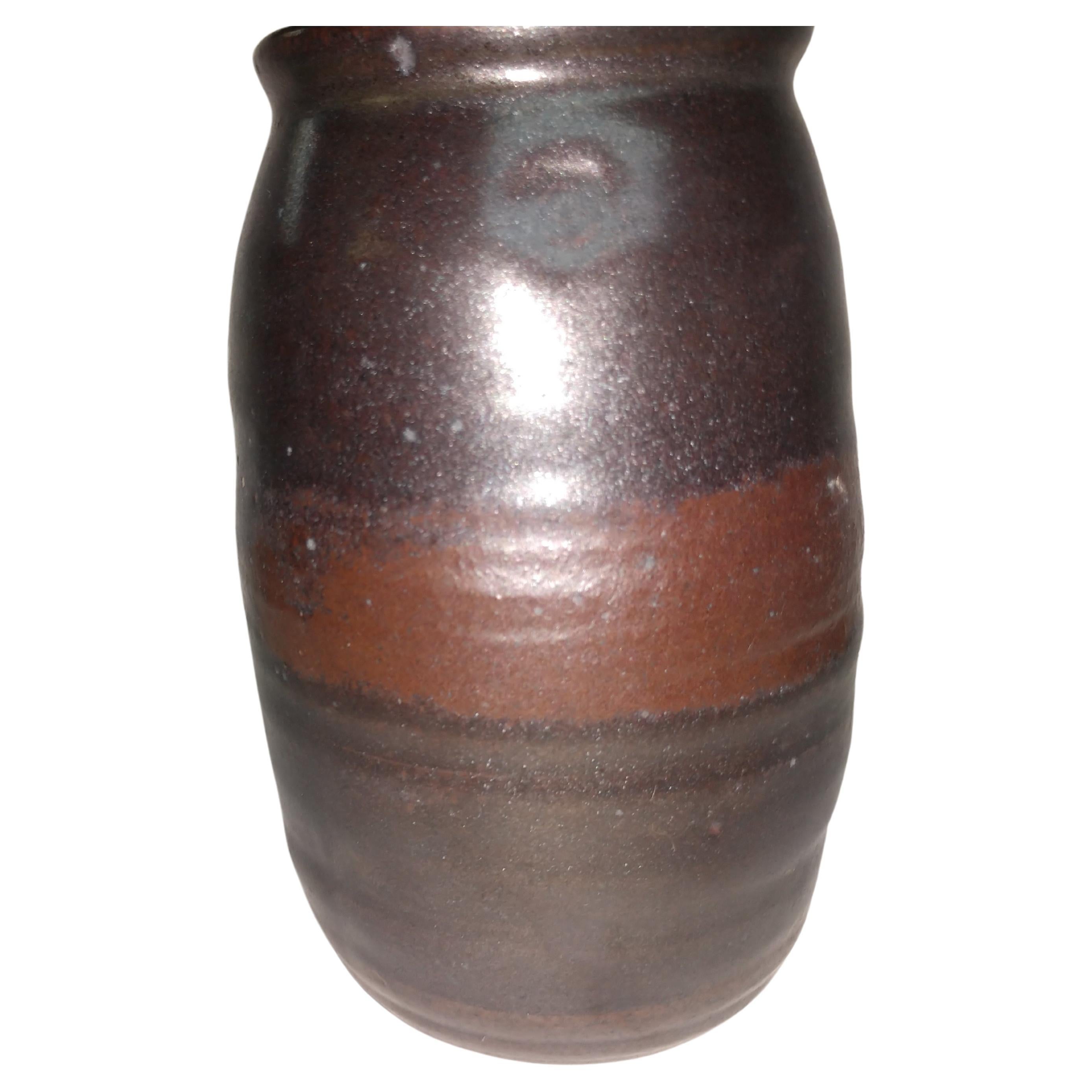 Elegant and simple hand thrown and with a brown glaze with a subtle band of contrasting color by Herbert Sargent who was a TV and movie writer who worked on the Johnny Carson Show and Saturday Night Live. We have about 20 of his pieces. All are