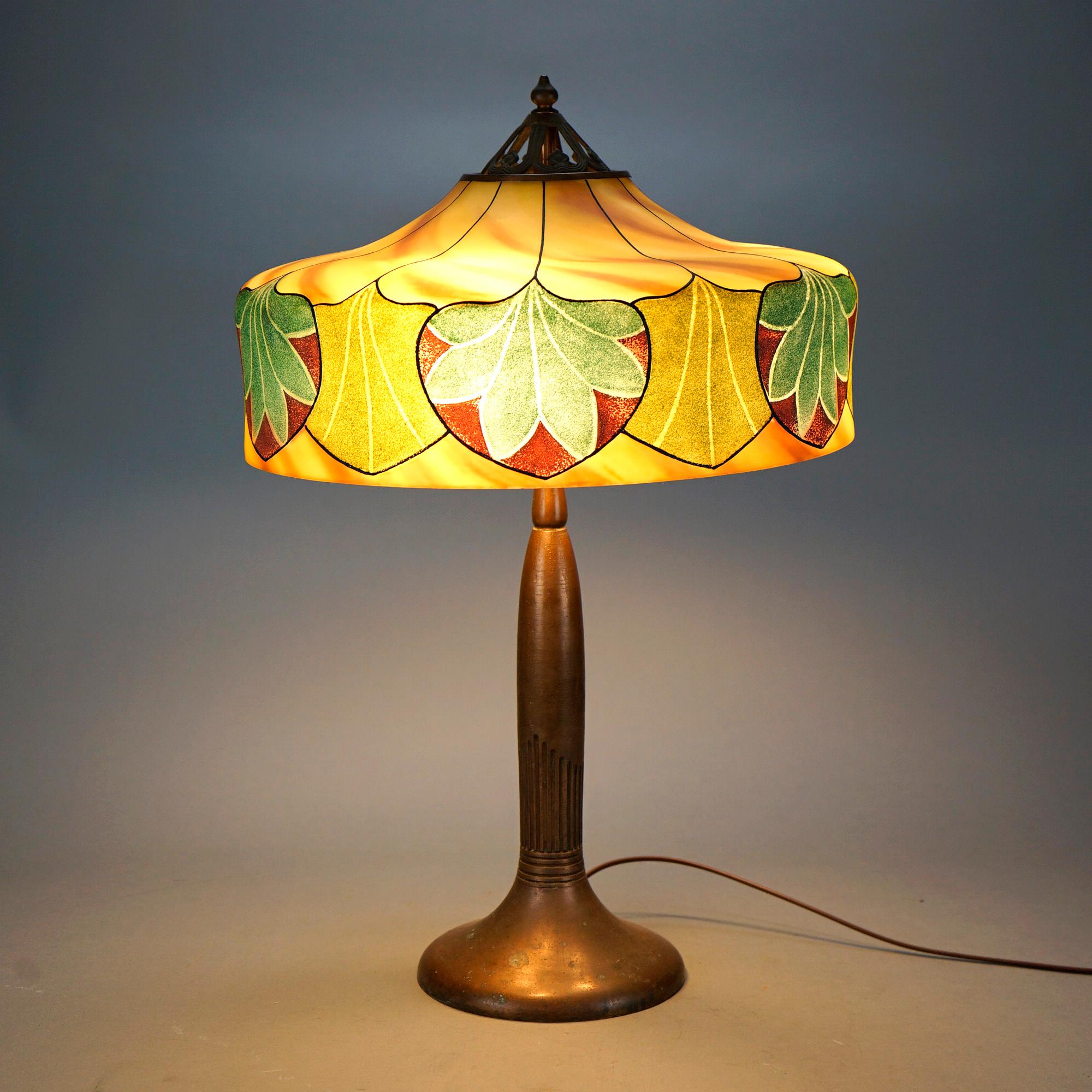 An antique Arts and Crafts table lamp by Handel offers obvers and reverse painted shade having repeating stylized foliate design over triple socket base, both elements signed Handel, shade No 5347, c1920.

Measures- 24.5''H x 16''W x