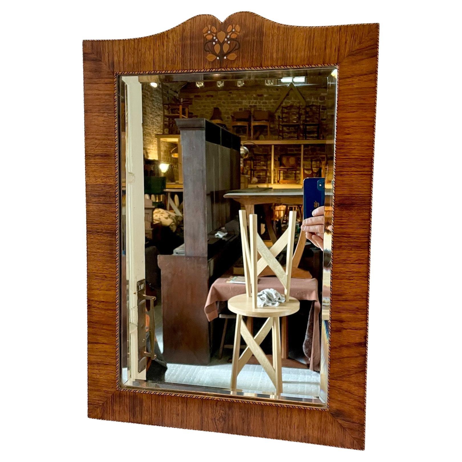 A very pretty Arts & Crafts wall mirror
The frame is made from rosewood
With a decorative mother of pearl and fruit wood inlay floral design to the top
There is a chequerboard inlay design to the perimeter
Circa 1900