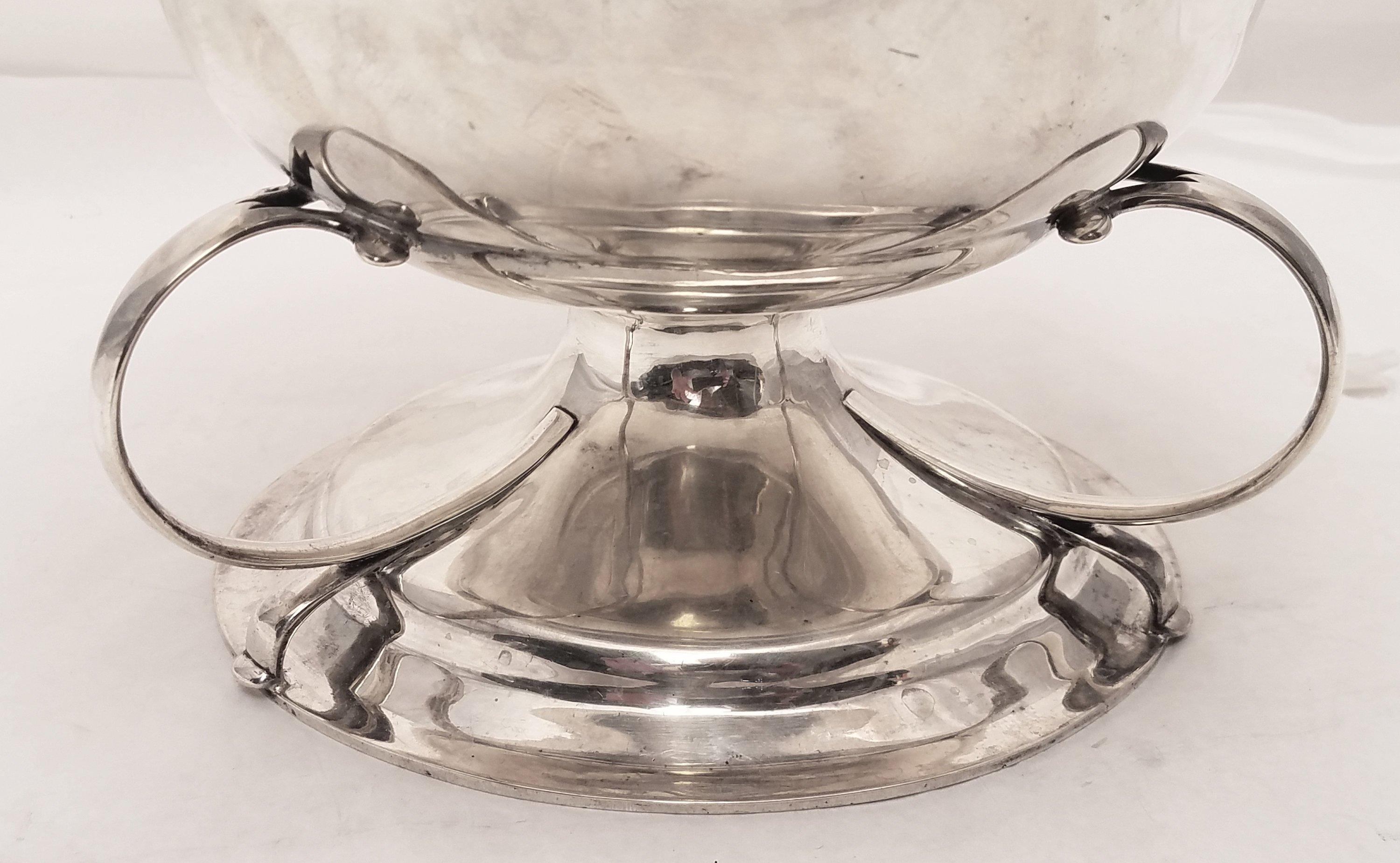 Arts and Crafts sterling silver 3-handled centerpiece / serving bowl, standing on a grounded pedestal base. Made by James Woolley, this beautiful centerpiece will do wonders for any holiday table setting! Measurements: 6.5 inches high, by 10.25