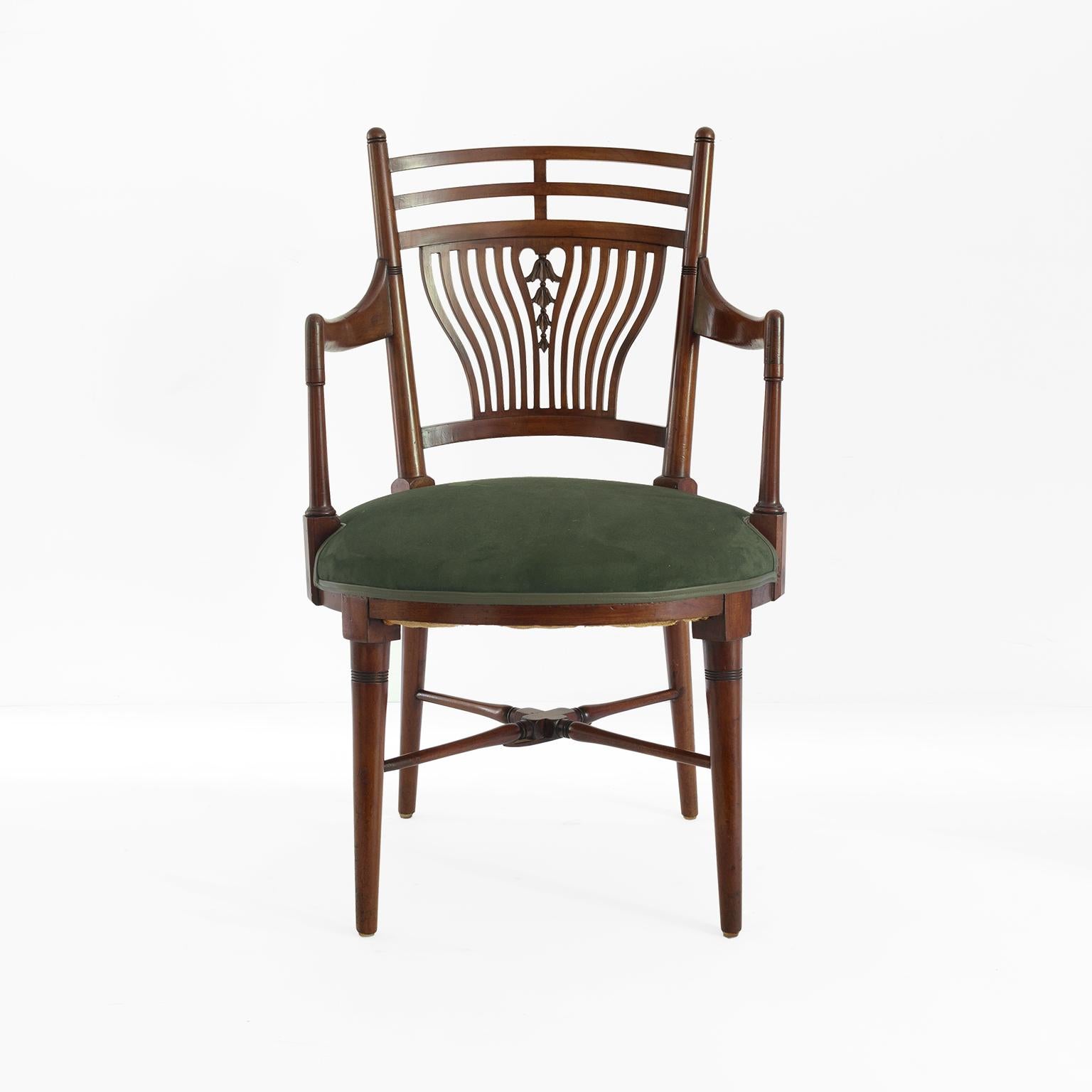 Arts & Crafts Jacobean armchair (1870-1880) possibly designed by Edward William Godwin and produced for William Watt. The chairs features a backrest with ribs in a wave pattern with a lily stalk in the center. The hardwood frame has crossed leg