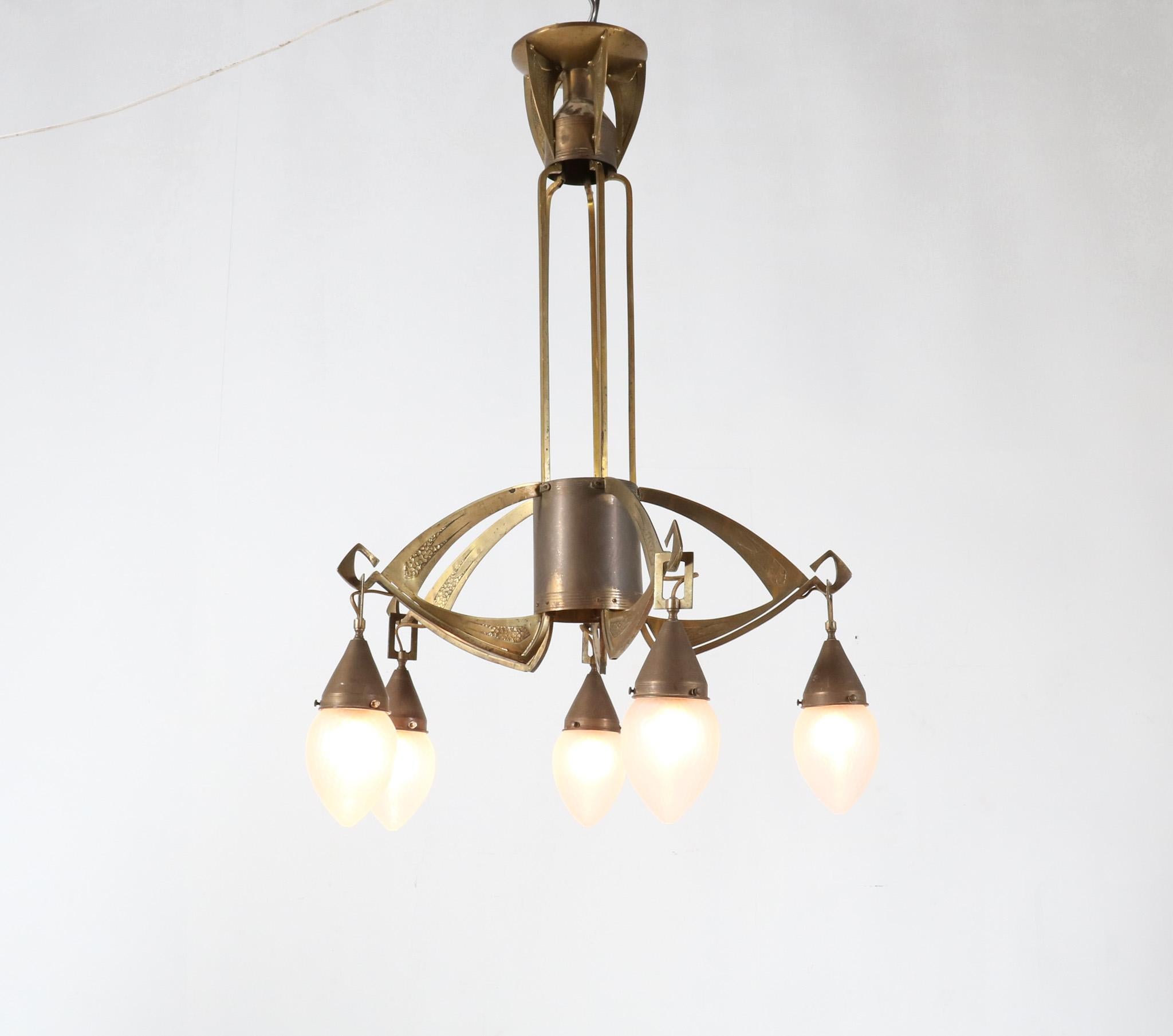 Magnificent and rare Arts & Crafts Jugendstil chandelier.
Striking Austrian or German design from the 1900s.
Original patinated brass frame with five original hand-blown glass shades.
In very good original condition with minor wear consistent