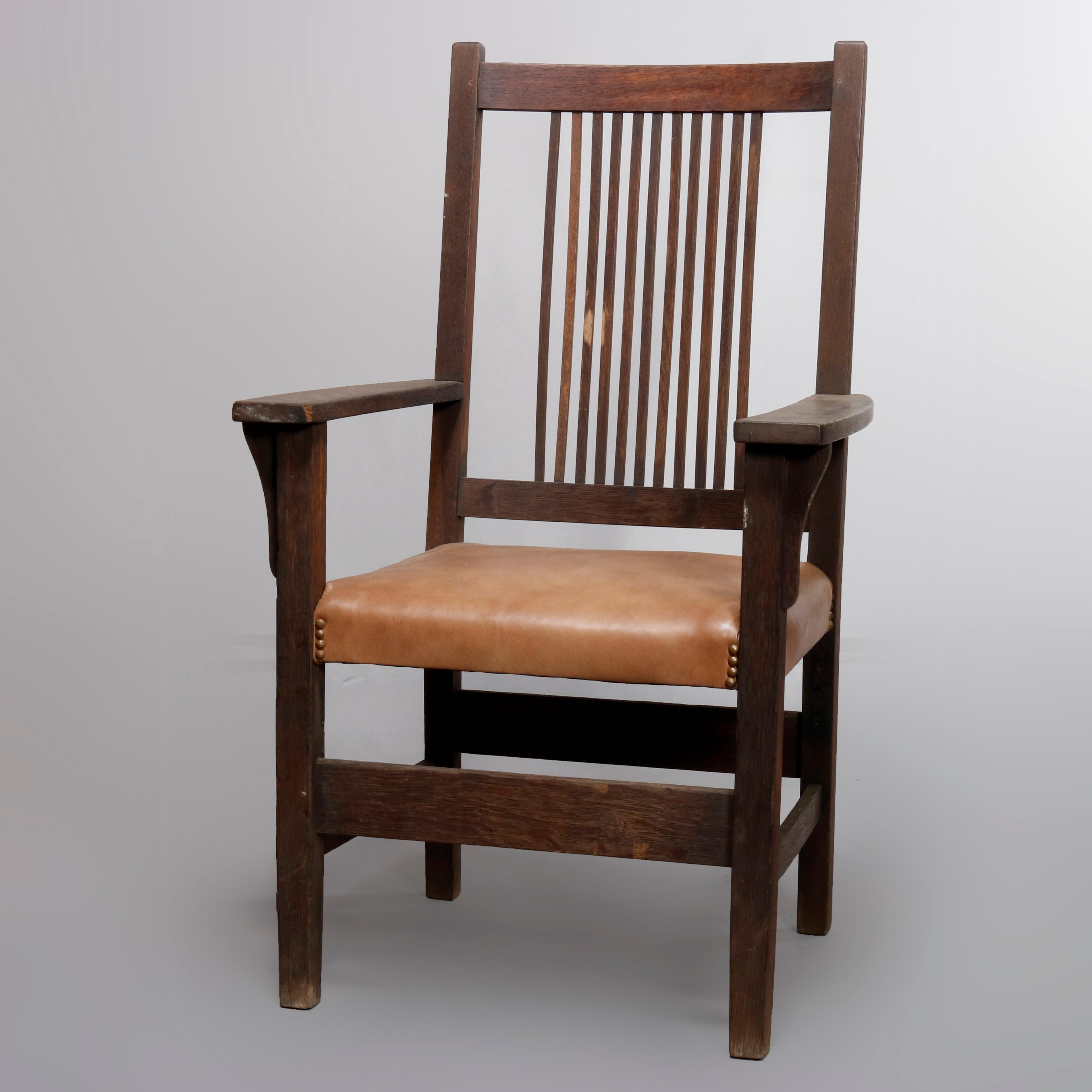 An Arts & Crafts Mission Oak L and J G Stickley armchair offers spindle back surmounting even armed seat raised on square and straight legs, circa 1910.

Measures: 43