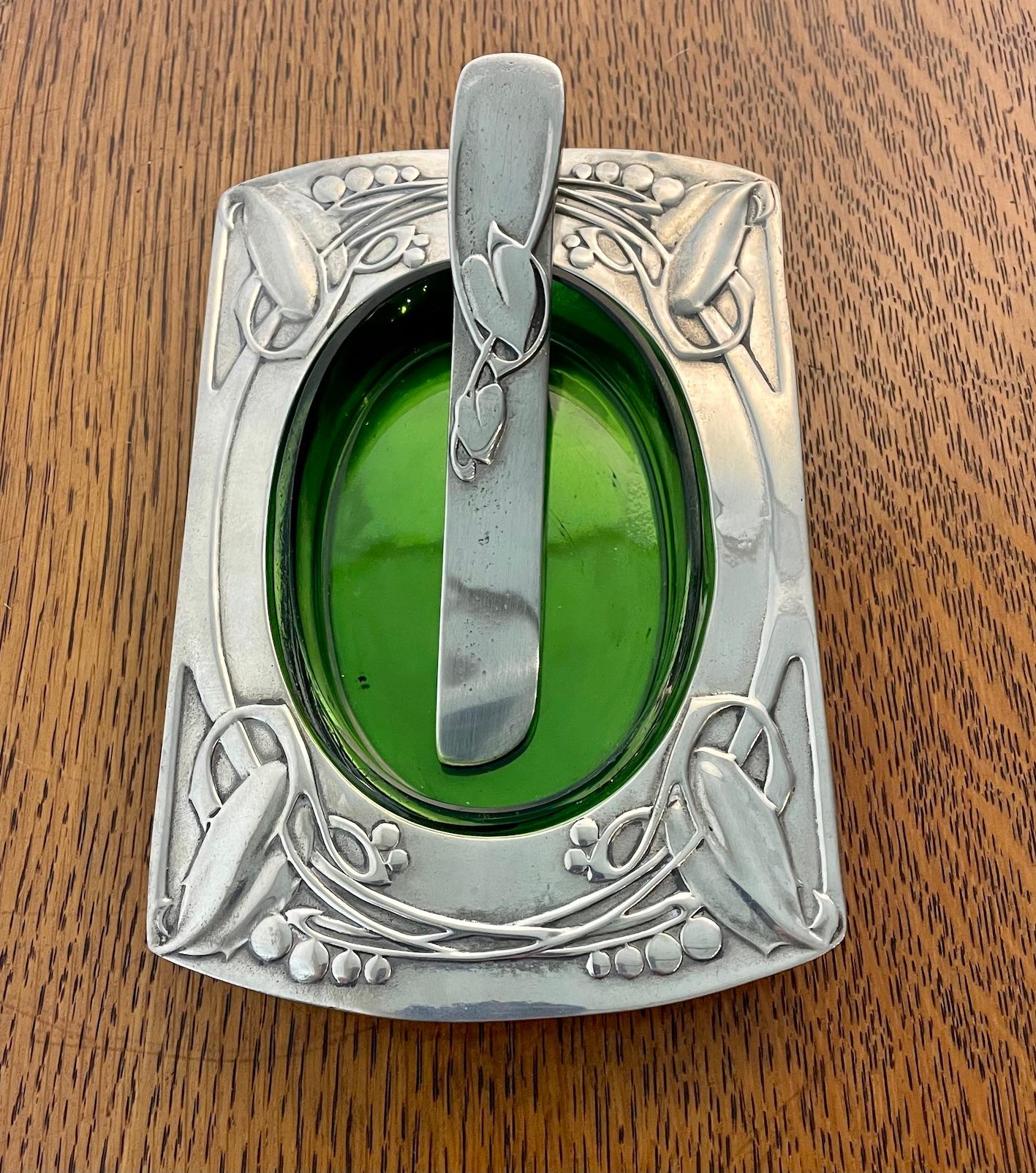 A fabulous Arts & Crafts butter dish and matching knife with the original green glass liner
The stylised Celtic decoration is a signature of the designer Archibald Knox
Retailed by Liberty & Co
Circa 1905
Marked Solketts

Archibald Knox 1864 -